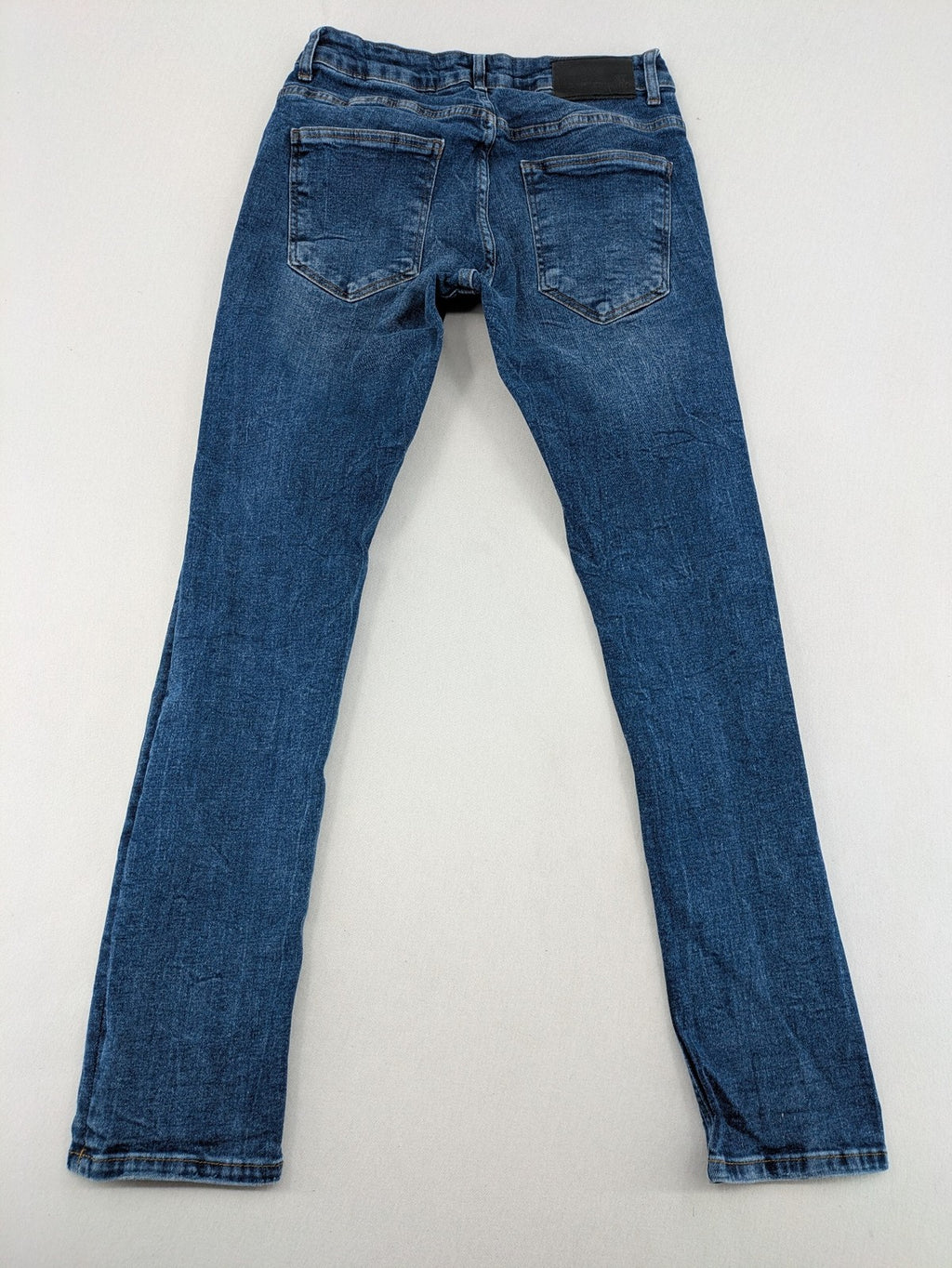 2Y Premium blue skinny jeans with distressed details and classic button fly.