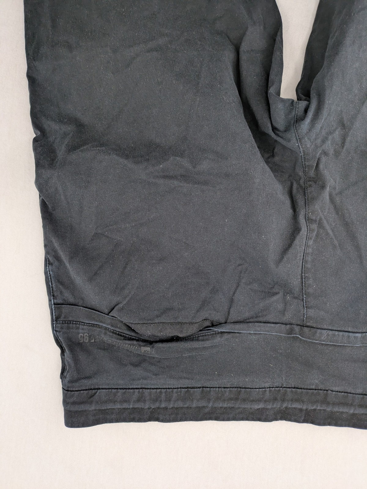 4F black cargo pants with reinforced knees, made from cotton-stretch material.