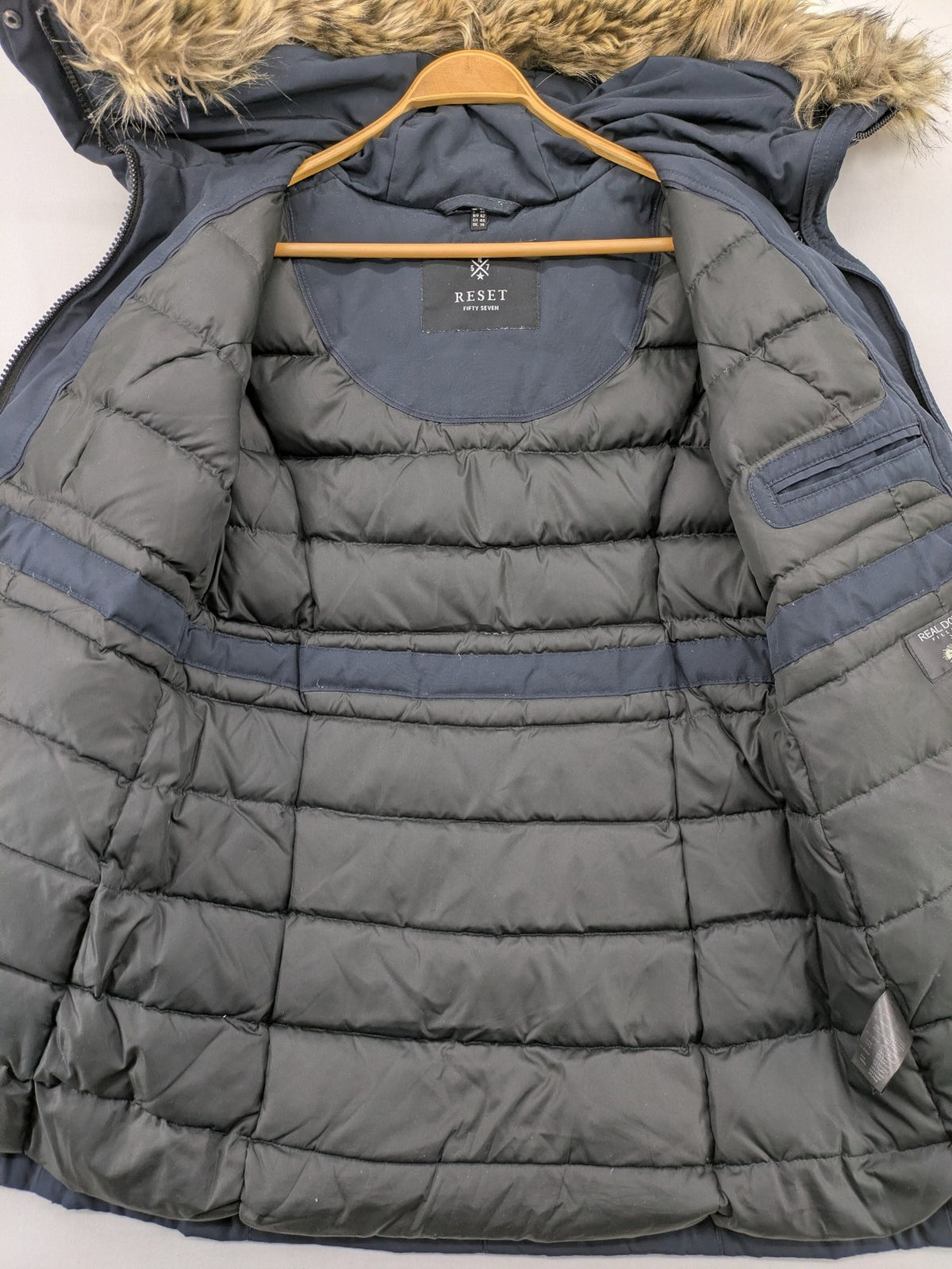 Reset Fifty Seven cream puffer coat with faux fur hood and down insulation.