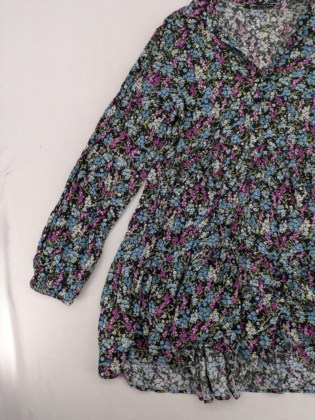 Zara multi-coloured floral mini dress with classic collar and button placket on black background.