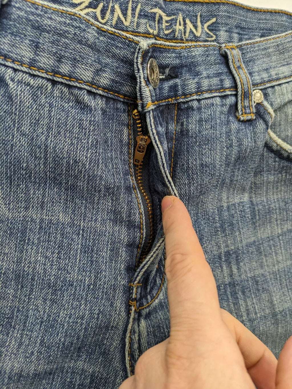 Zuni blue straight jeans 5-pocket design with zipper and decorative rivets.