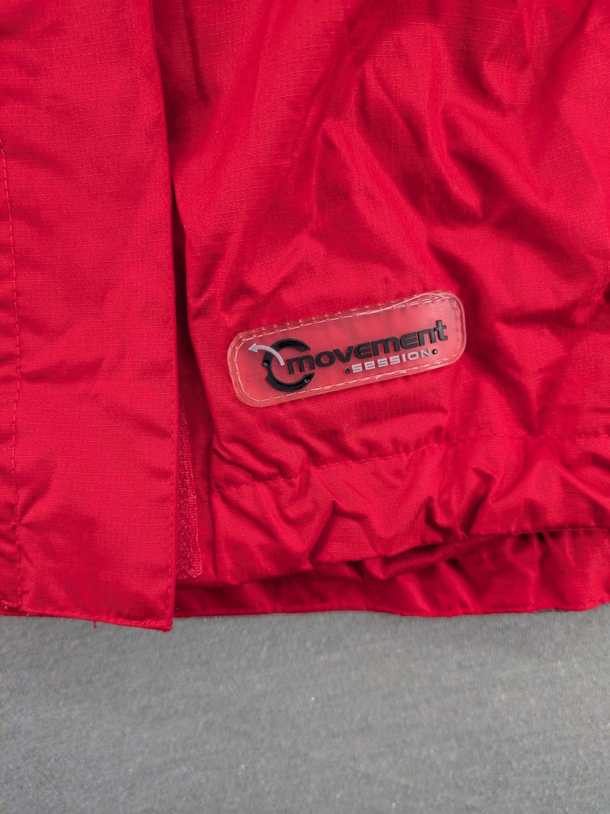 Movement Session grey and red windbreaker jacket with colorblock pattern and full zip.