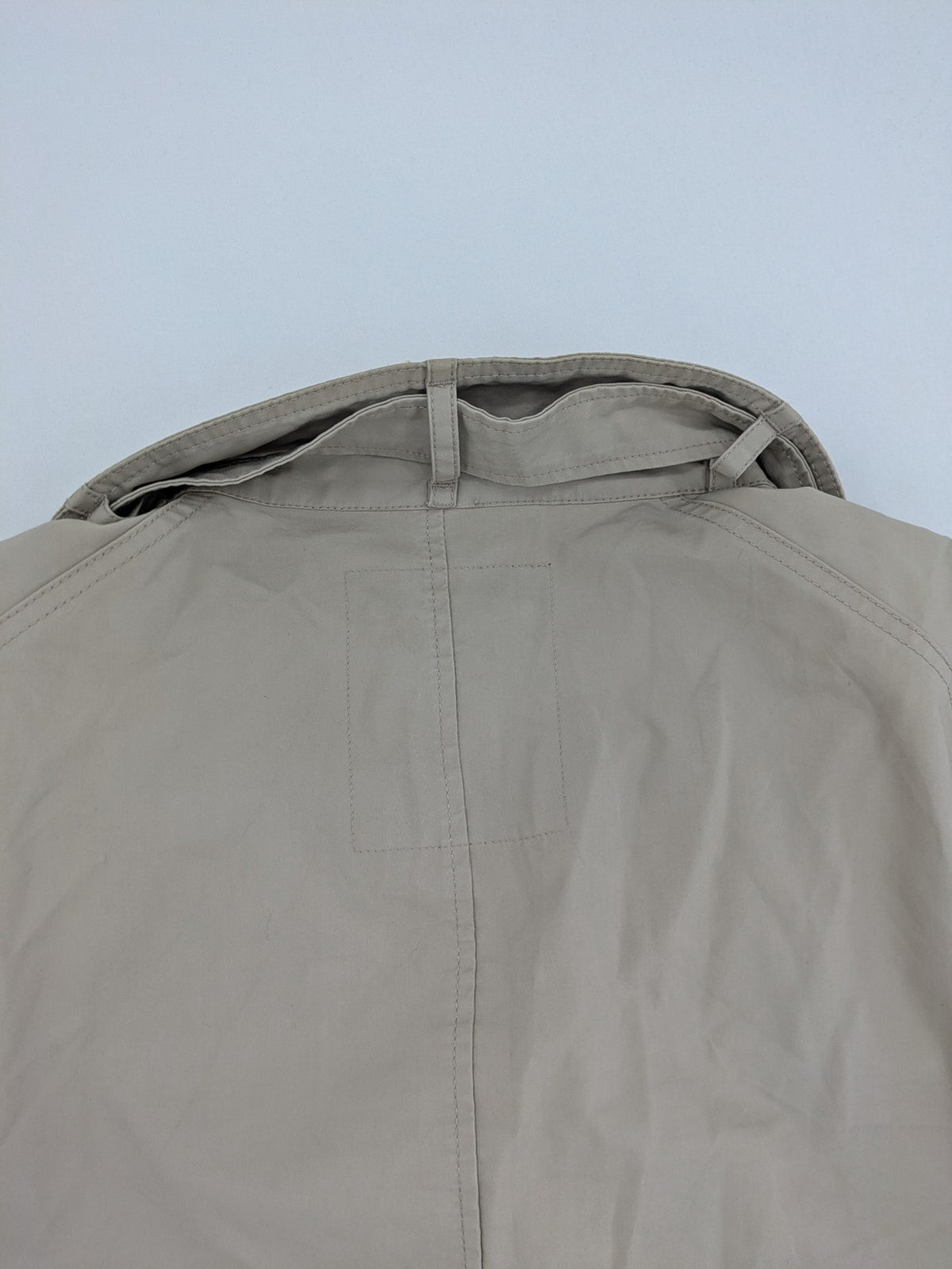ReSET beige coat with contrasting dark blue lining and classic design details.