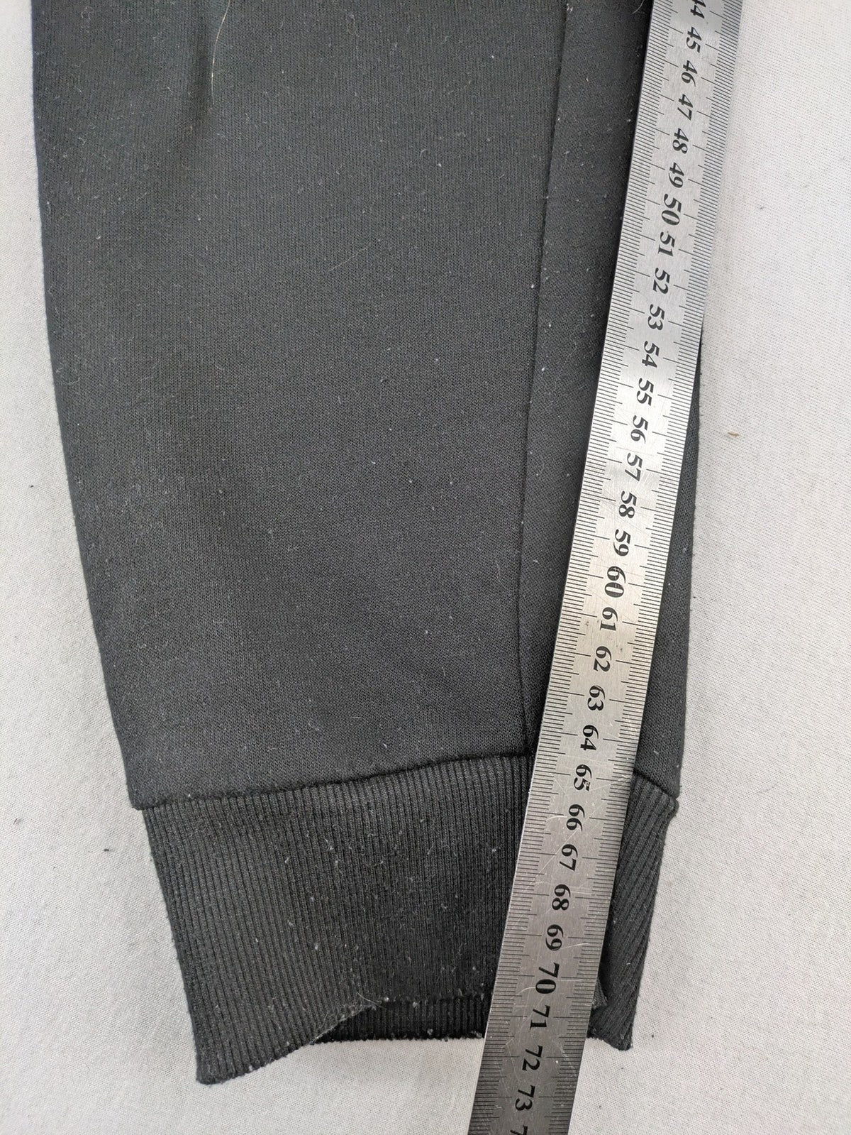 Kuyruun black jogging pants with kangaroo logo, elastic waistband, and ribbed cuffs.