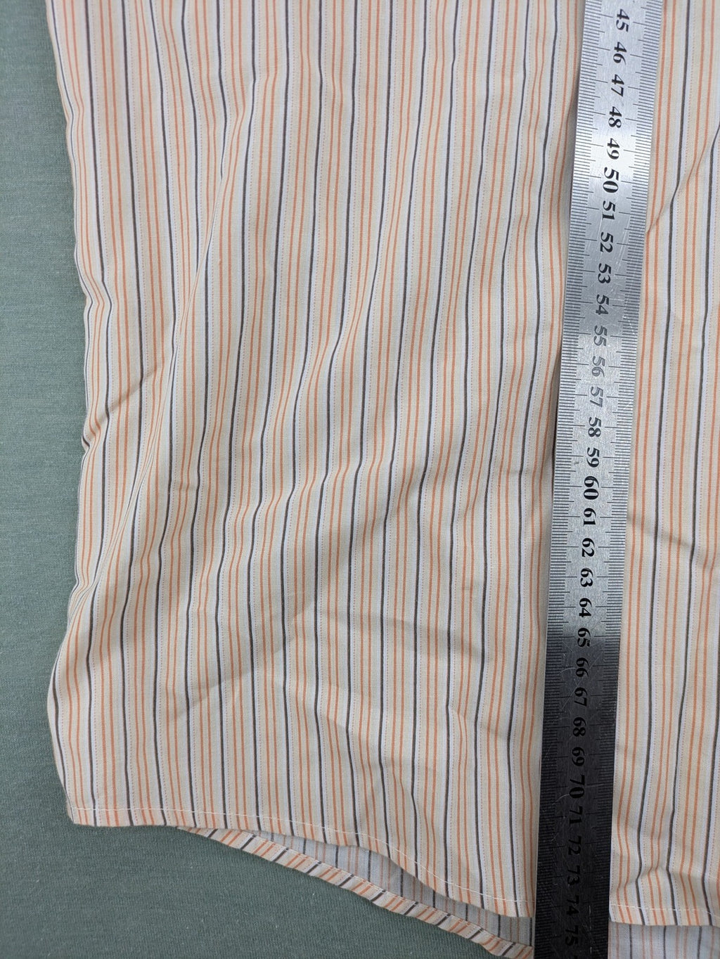 Ken Baker orange short-sleeve shirt with vertical stripes and chest pocket.