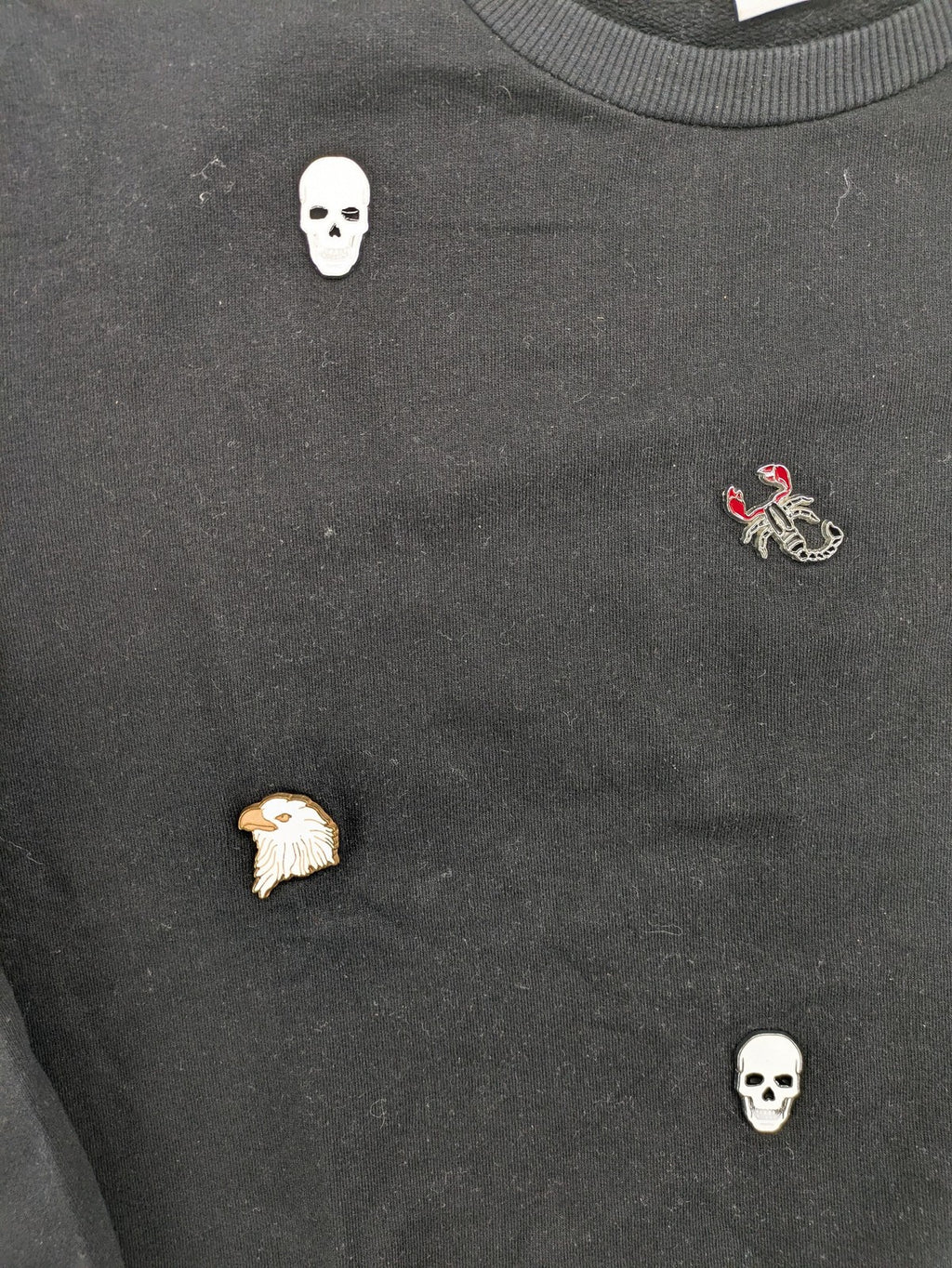 Zara grey turtle neck jumper with skull, scorpion, flame, and eagle embellishments.