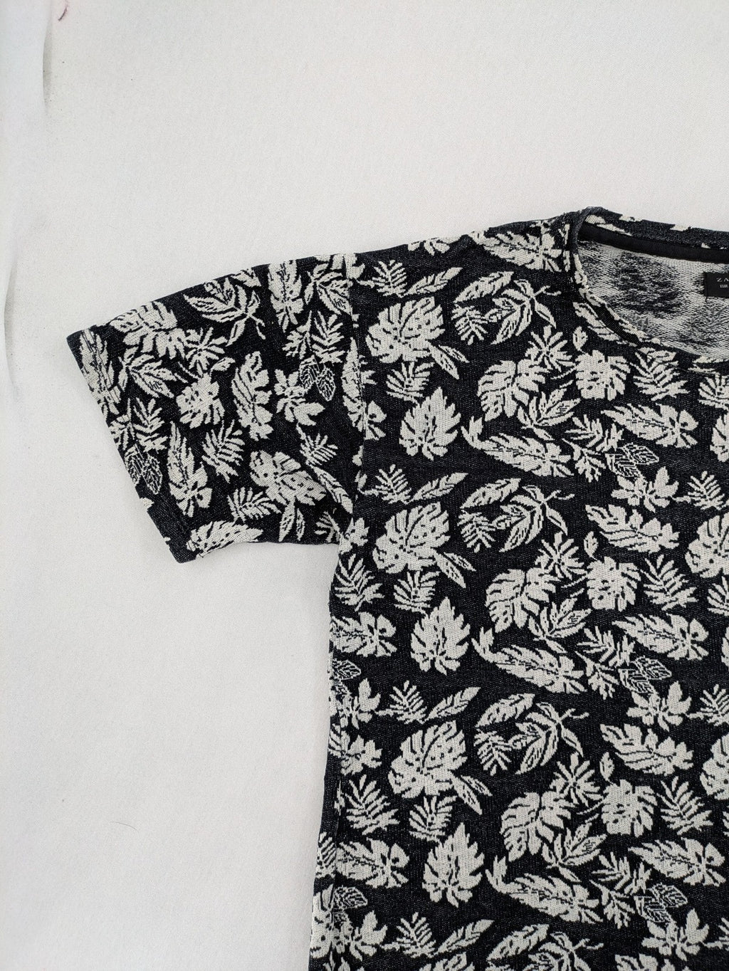 Zara Man black and white t-shirt with allover leaf print and textured knit fabric.
