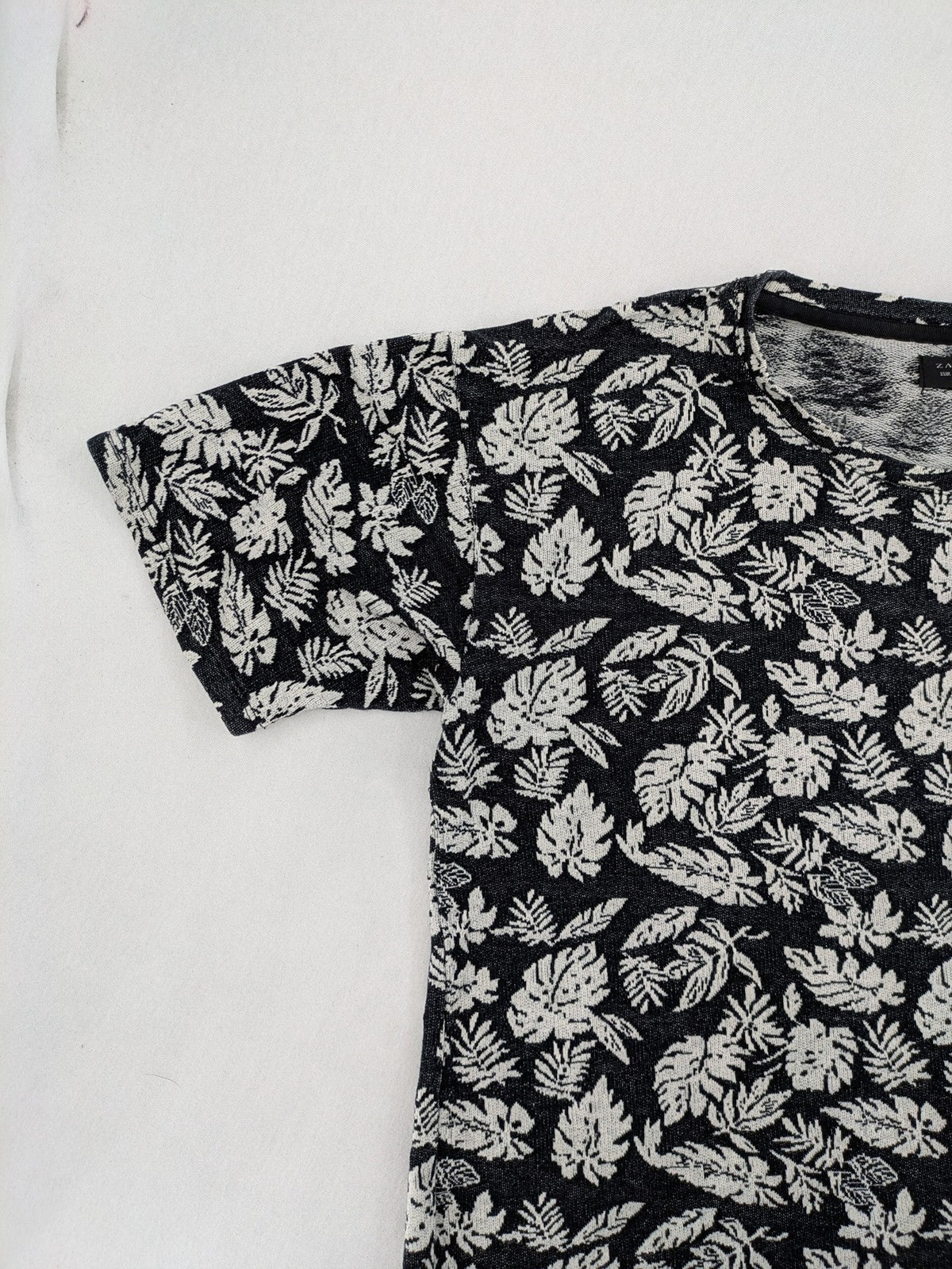 Zara Man black and white t-shirt with allover leaf print and textured knit fabric.