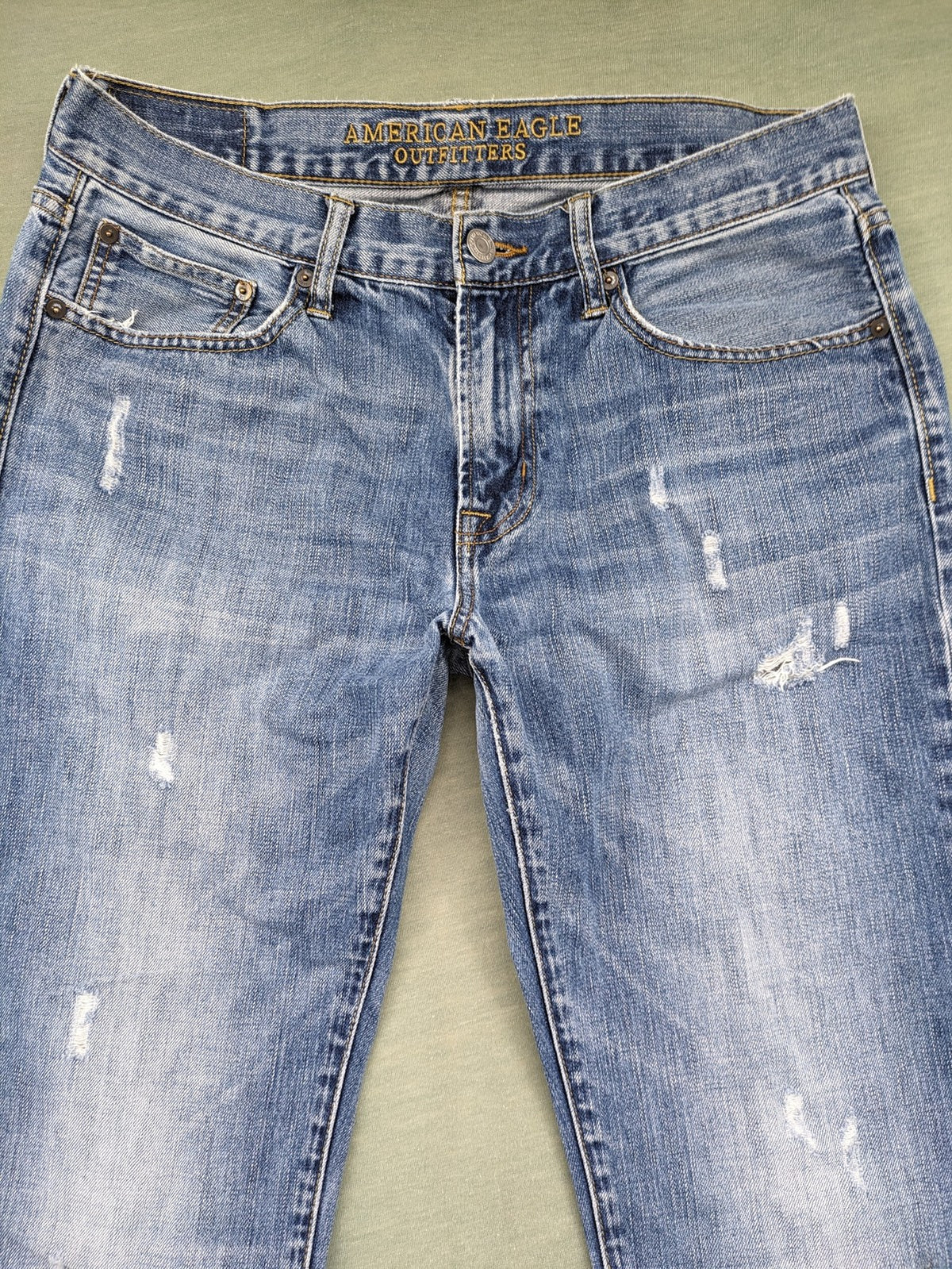 American Eagle Outfitters blue straight jeans with distressed detailing and classic five-pocket design.