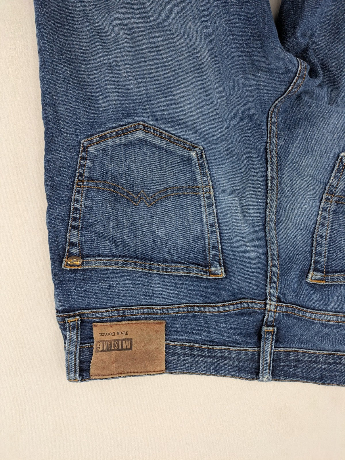 Mustang blue tapered jeans with slim fit, medium rise, and classic denim texture.