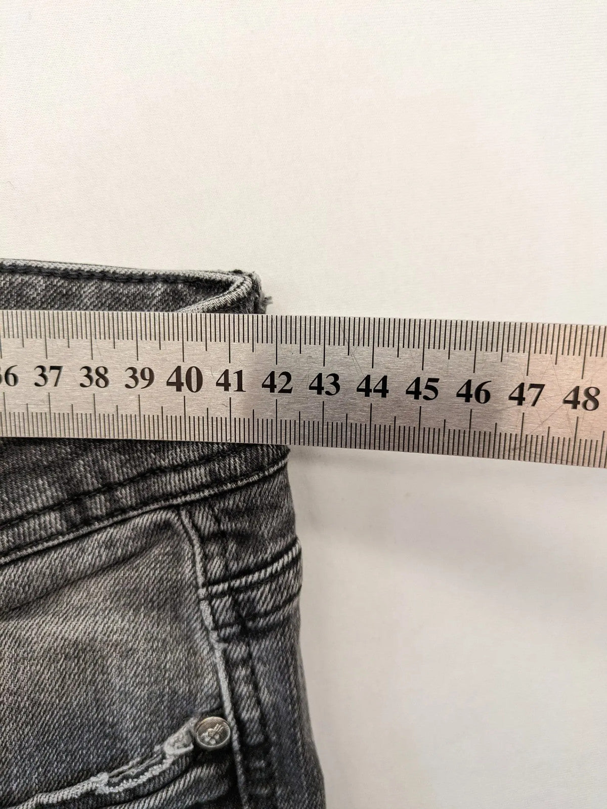 Denim grey straight jeans 5-pocket design with subtle brand details and zipper closure.