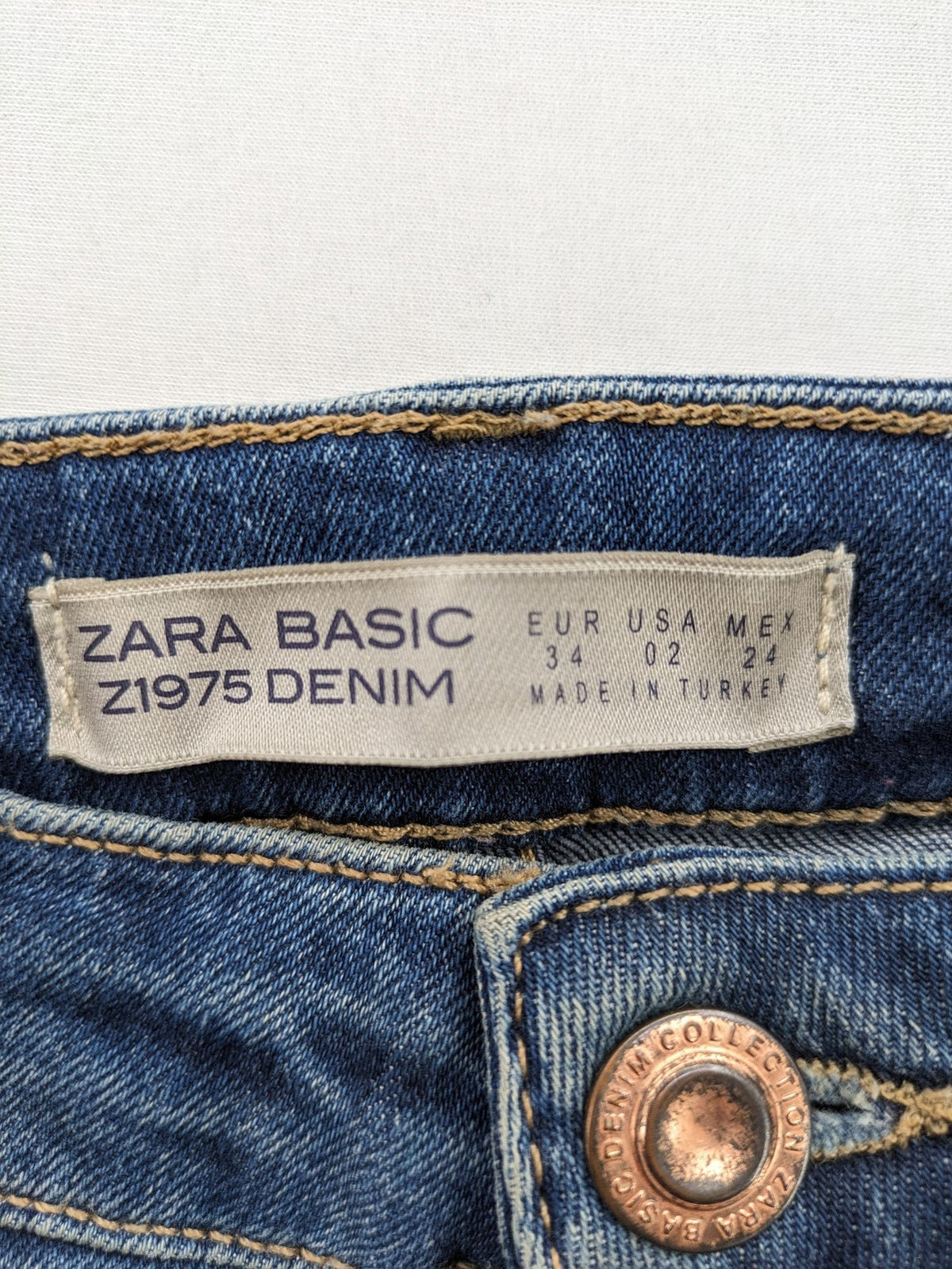 Zara Basic blue skinny jeans with destroyed knee details and frayed hem.