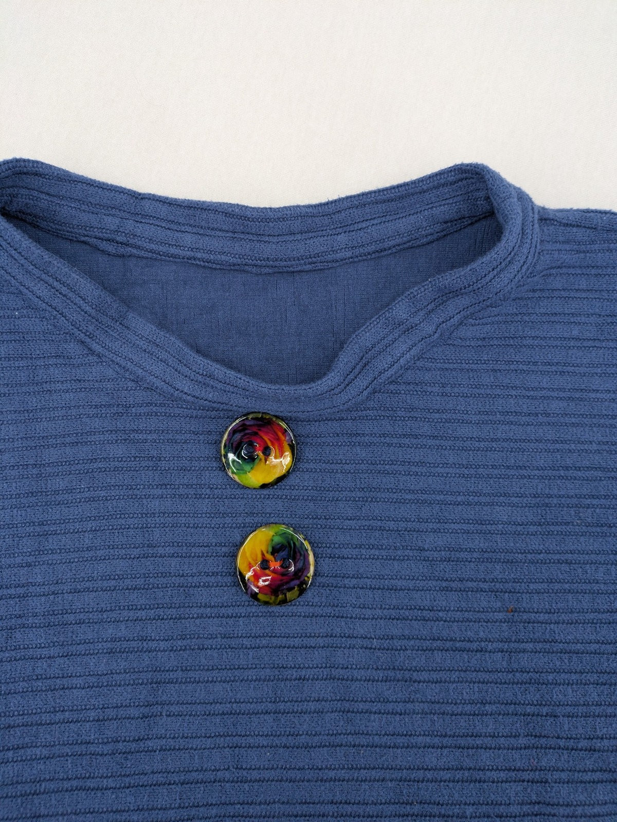 Secondhand blue tank top with ribbed texture and colorful decorative buttons.
