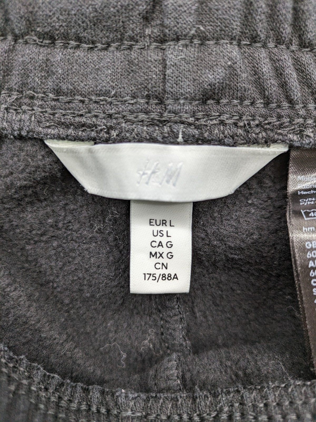 H&M black sweatpants with adjustable drawstring, elastic cuffs, and side pockets.