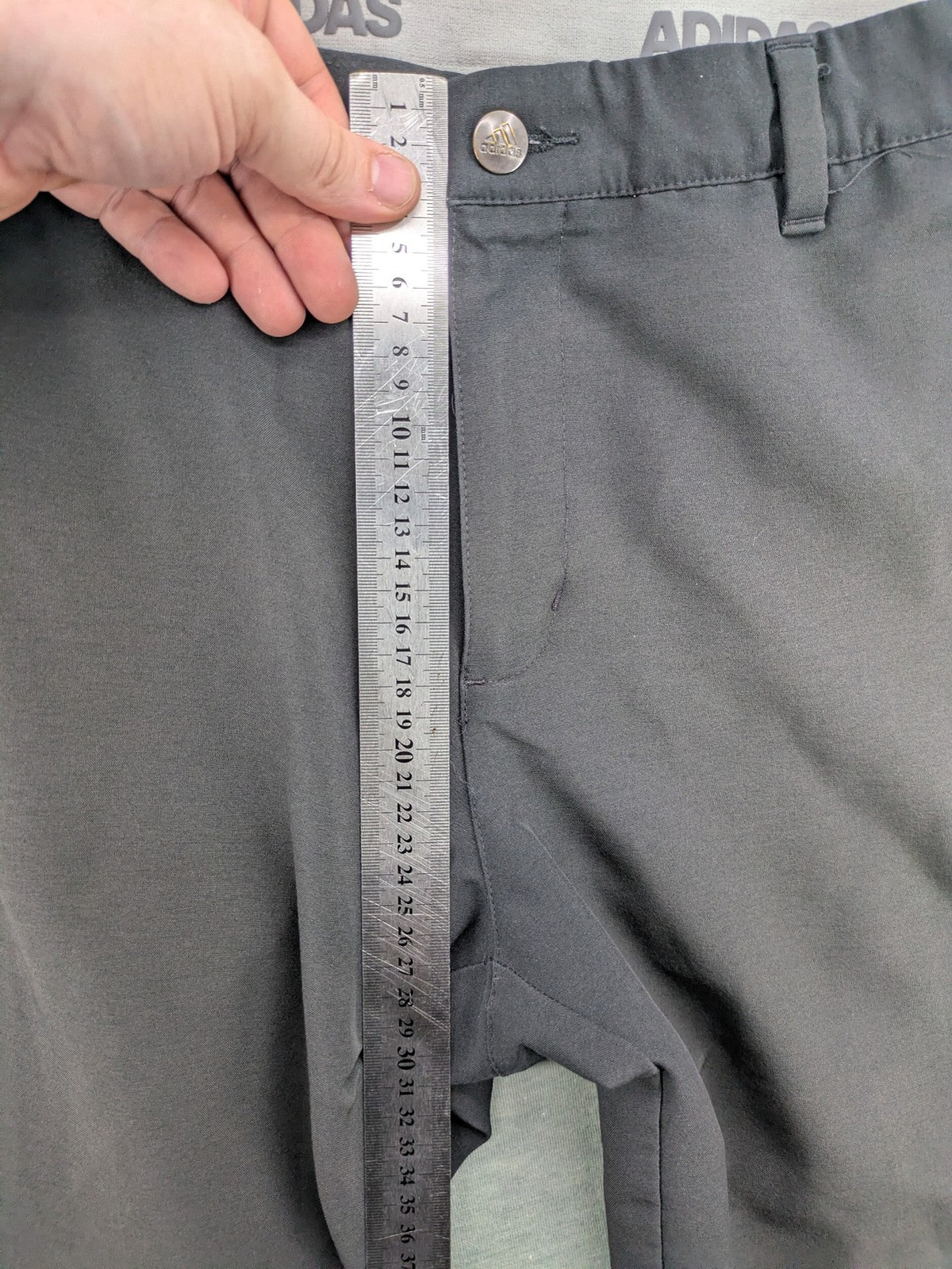 Adidas grey pants with 3-stripe logo, flat-front design, made from performance material.