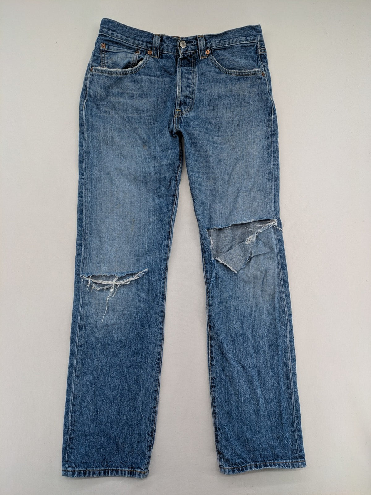 Levi's blue straight jeans with button-fly and distressed knee rips.