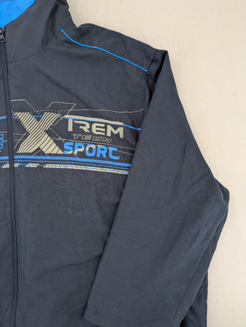 Atlas for Men blue windbreaker jacket with XTREM TECH SPORT graphic print and full zip.