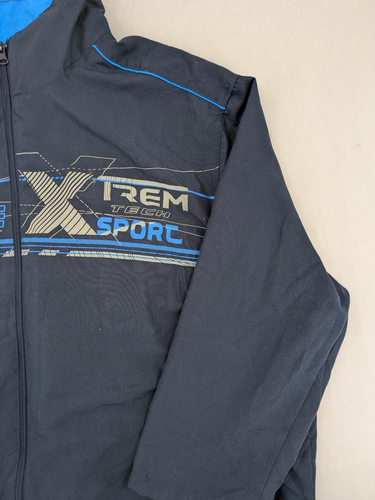 Atlas for Men blue windbreaker jacket with XTREM TECH SPORT graphic print and full zip.