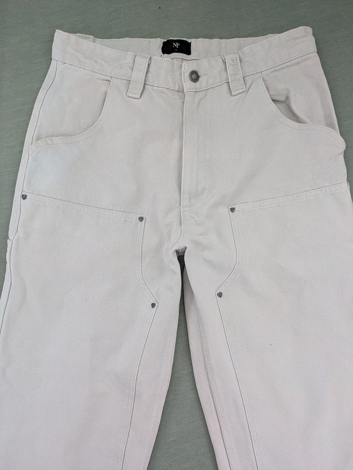 NUDE beige pants with double knee reinforcements and multiple utility pockets.