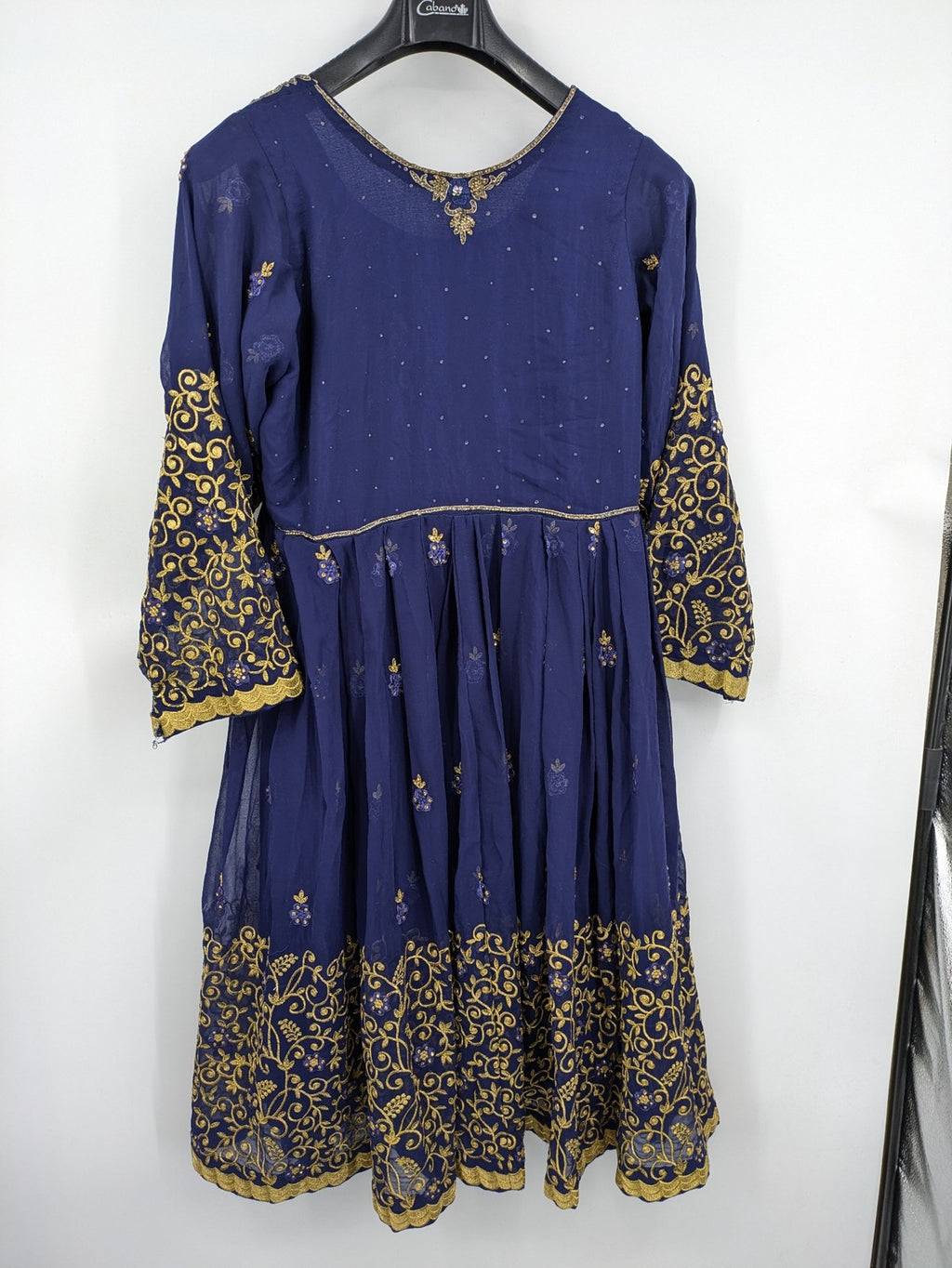 Bollywood bridal party dress gold with intricate blue embroidery and flowing Anarkali silhouette.