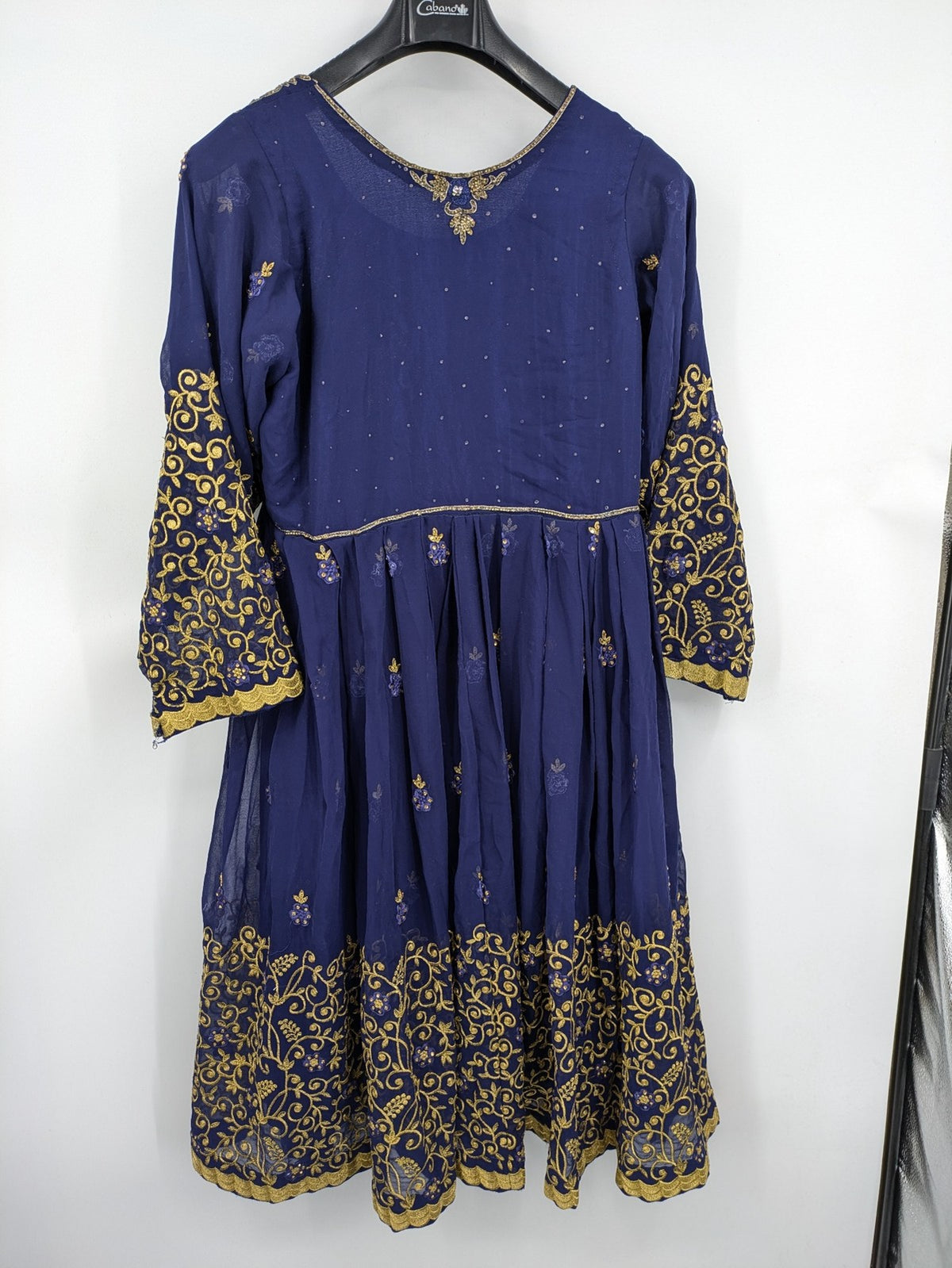Bollywood bridal party dress gold with intricate blue embroidery and flowing Anarkali silhouette.