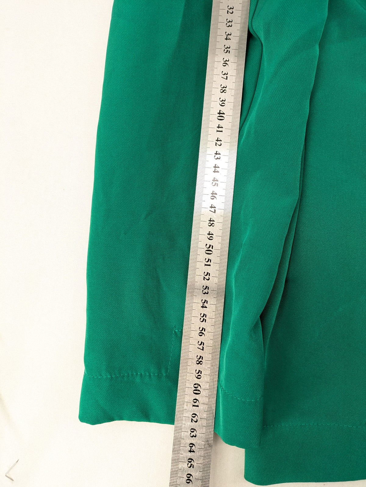 Promiss green blazer jacket single-button design with notch lapels and decorative pockets.