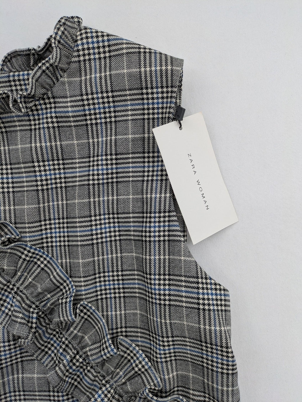 Zara ruffled sleeveless blouse grey check pattern high ruffle collar with blue, black, white accents
