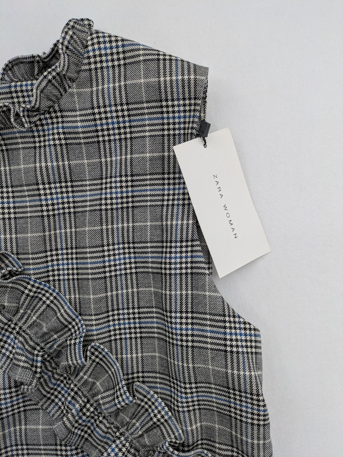 Zara ruffled sleeveless blouse grey check pattern high ruffle collar with blue, black, white accents
