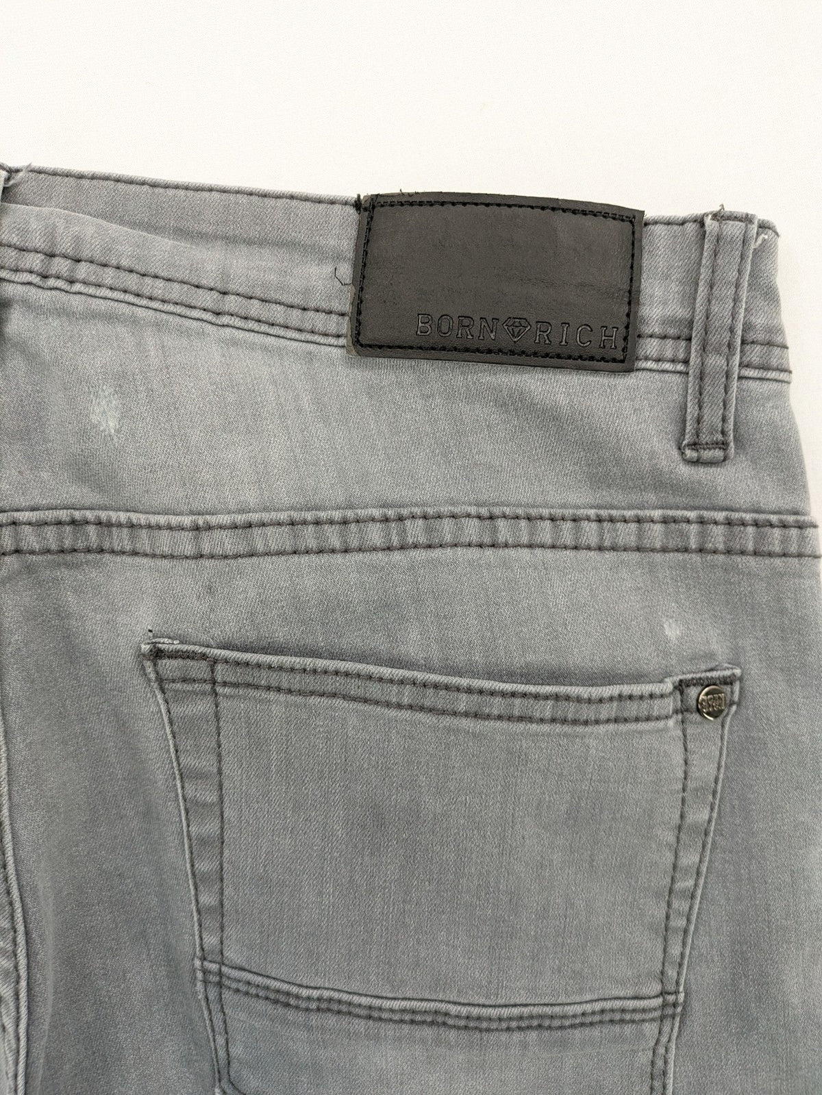 Born Rich grey slim fit jeans with logo patch and washed denim look.