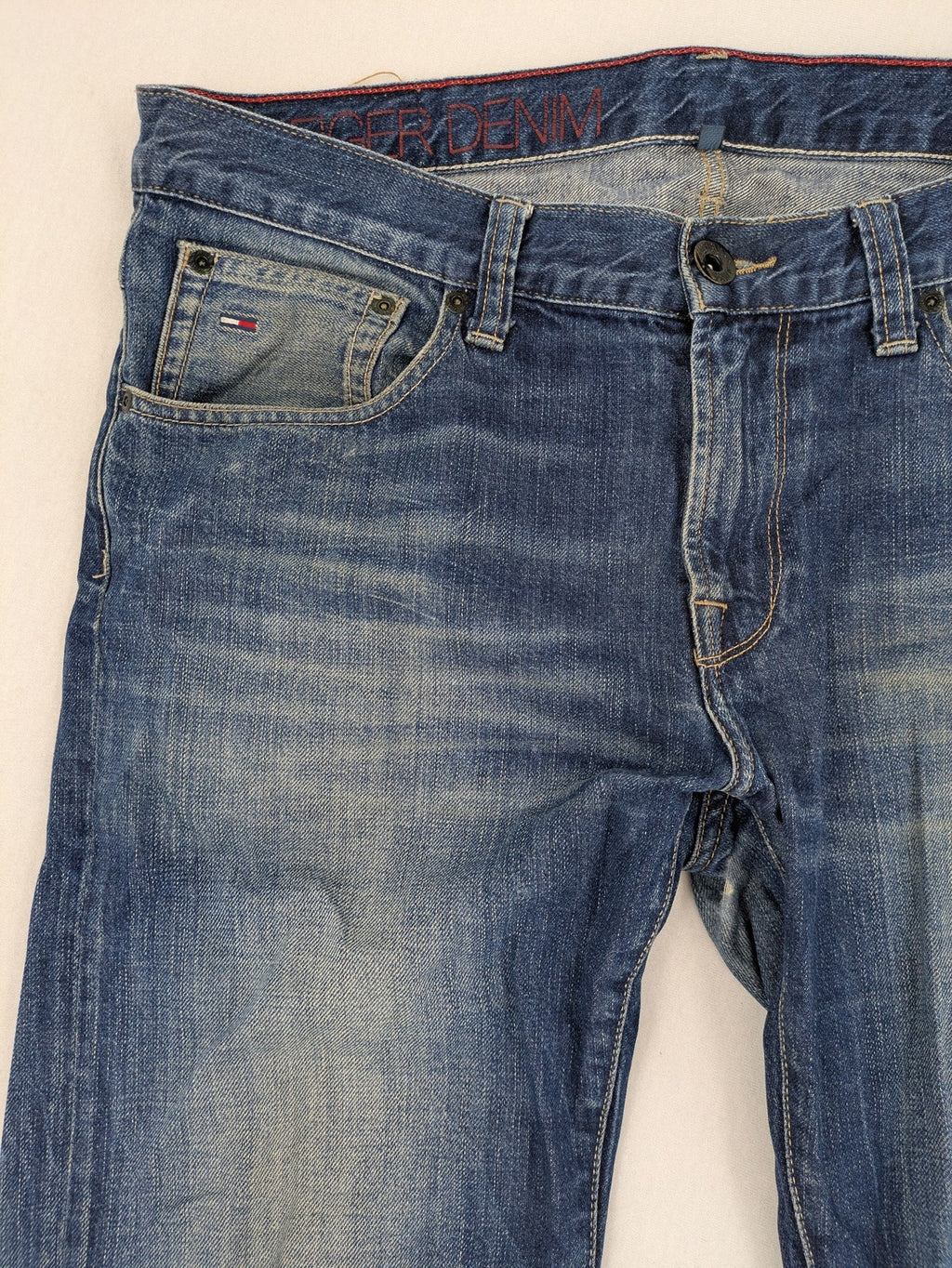 Hilfiger Denim blue straight jeans faded wash with Tommy Hilfiger flag logo on pocket.