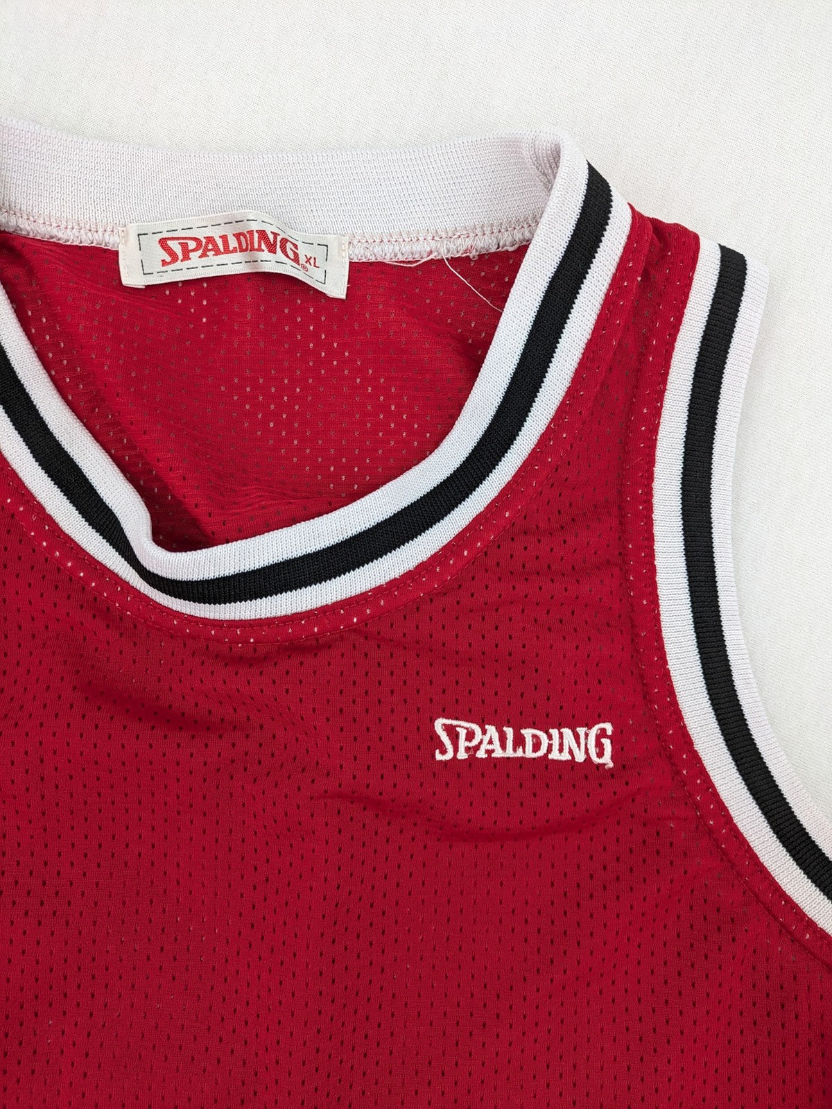 Spalding vintage red basketball jersey size XL, number 11, with black and white striped trim.