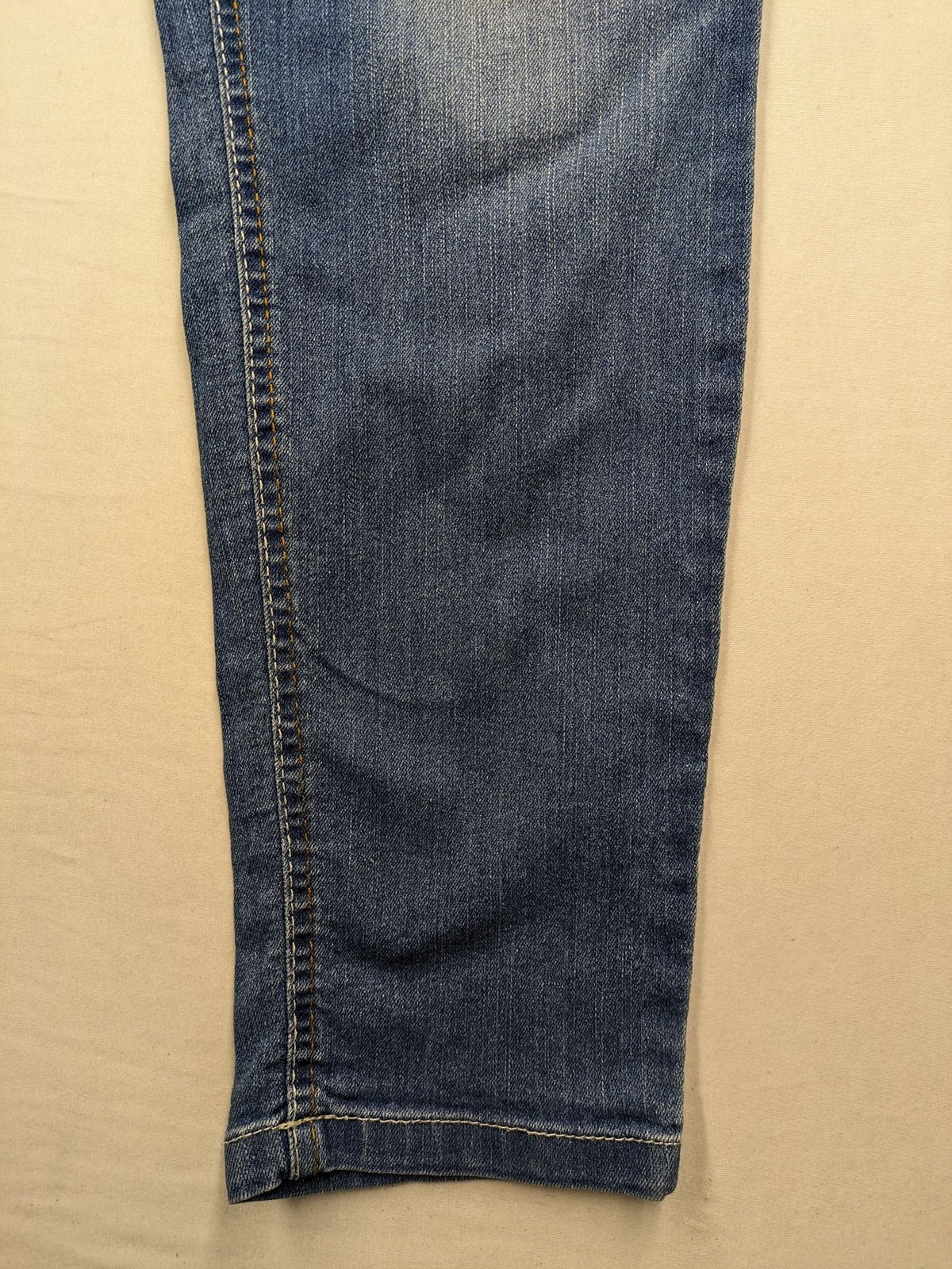 Rainbow blue straight jeans with elastic waistband and decorative knee stitching.