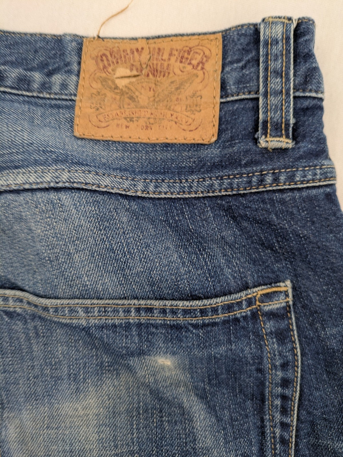 Hilfiger Denim blue straight jeans faded wash with Tommy Hilfiger flag logo on pocket.