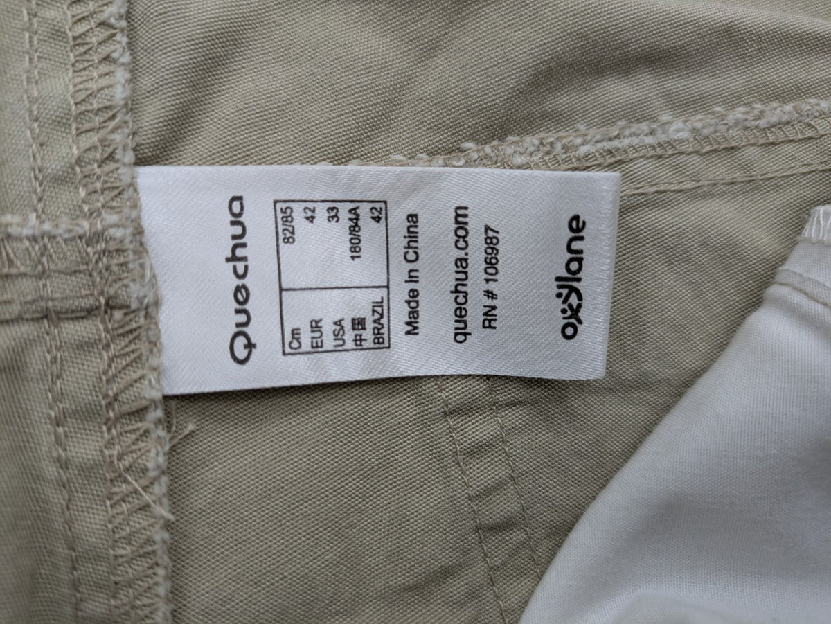 Quechua khaki convertible hiking pants with zip-off legs and durable cotton fabric.