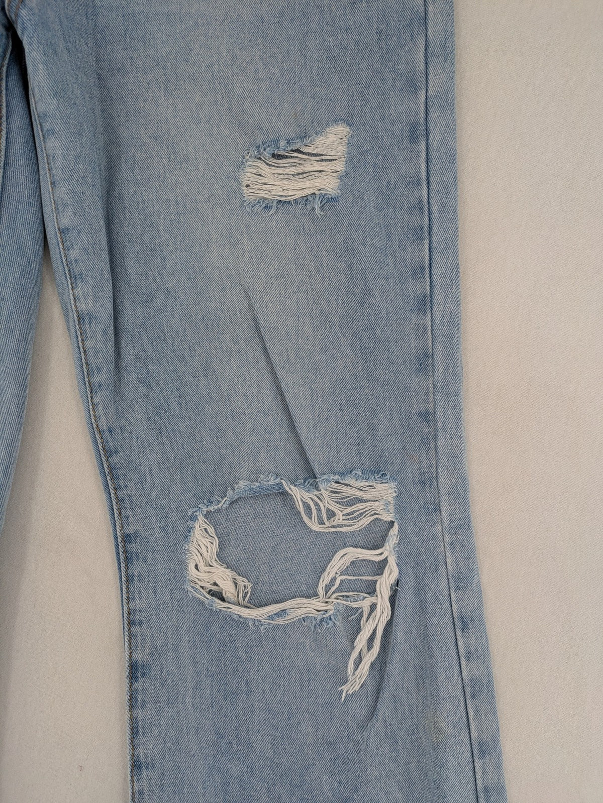 Laulia blue wide leg jeans with distressed knee rips and high waist design.