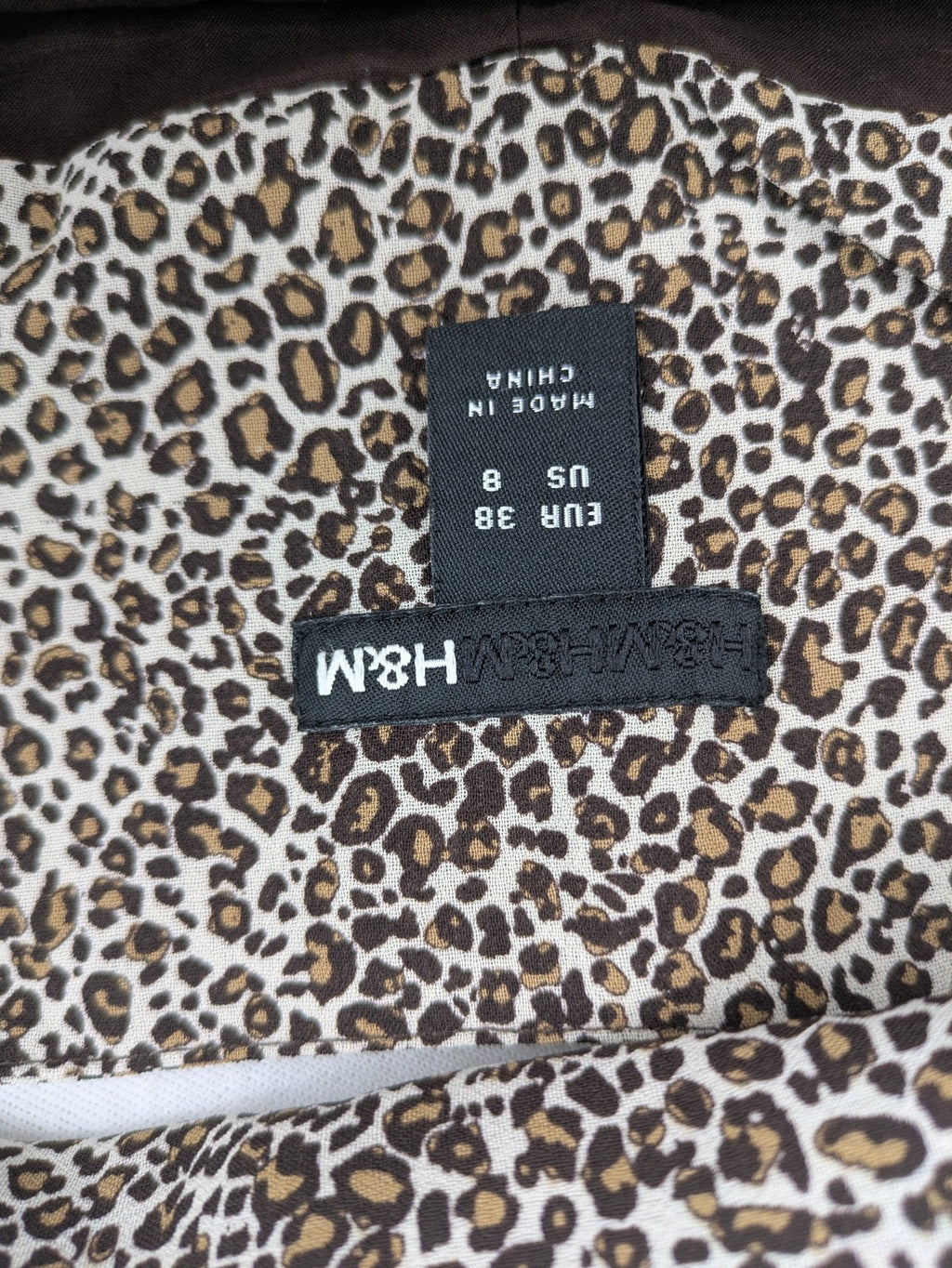 H&M women's A-line skirt beige brown leopard print ruffled hem and side tie detail.