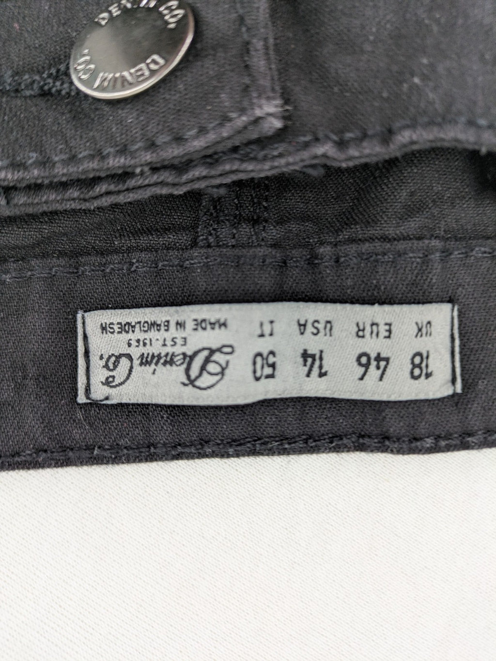 Denim & Co. black straight jeans with front button closure and back pockets.