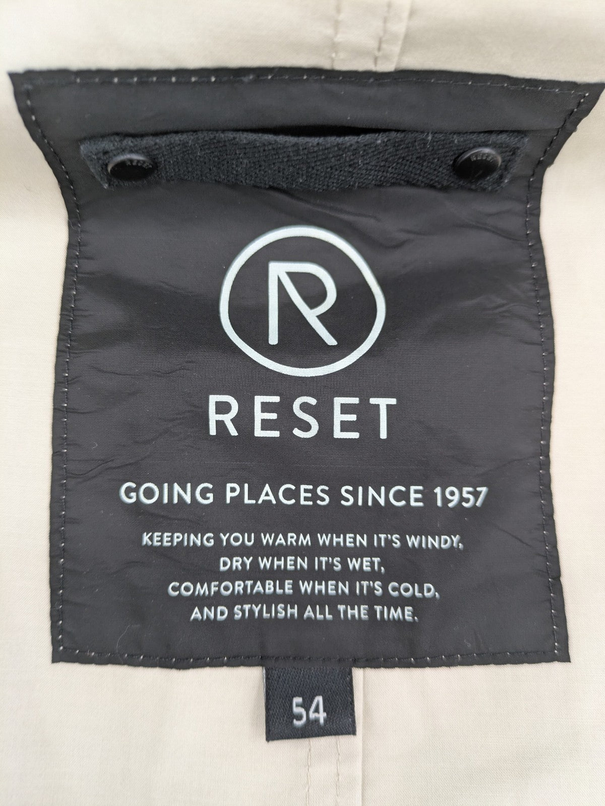 ReSET beige coat with contrasting dark blue lining and classic design details.
