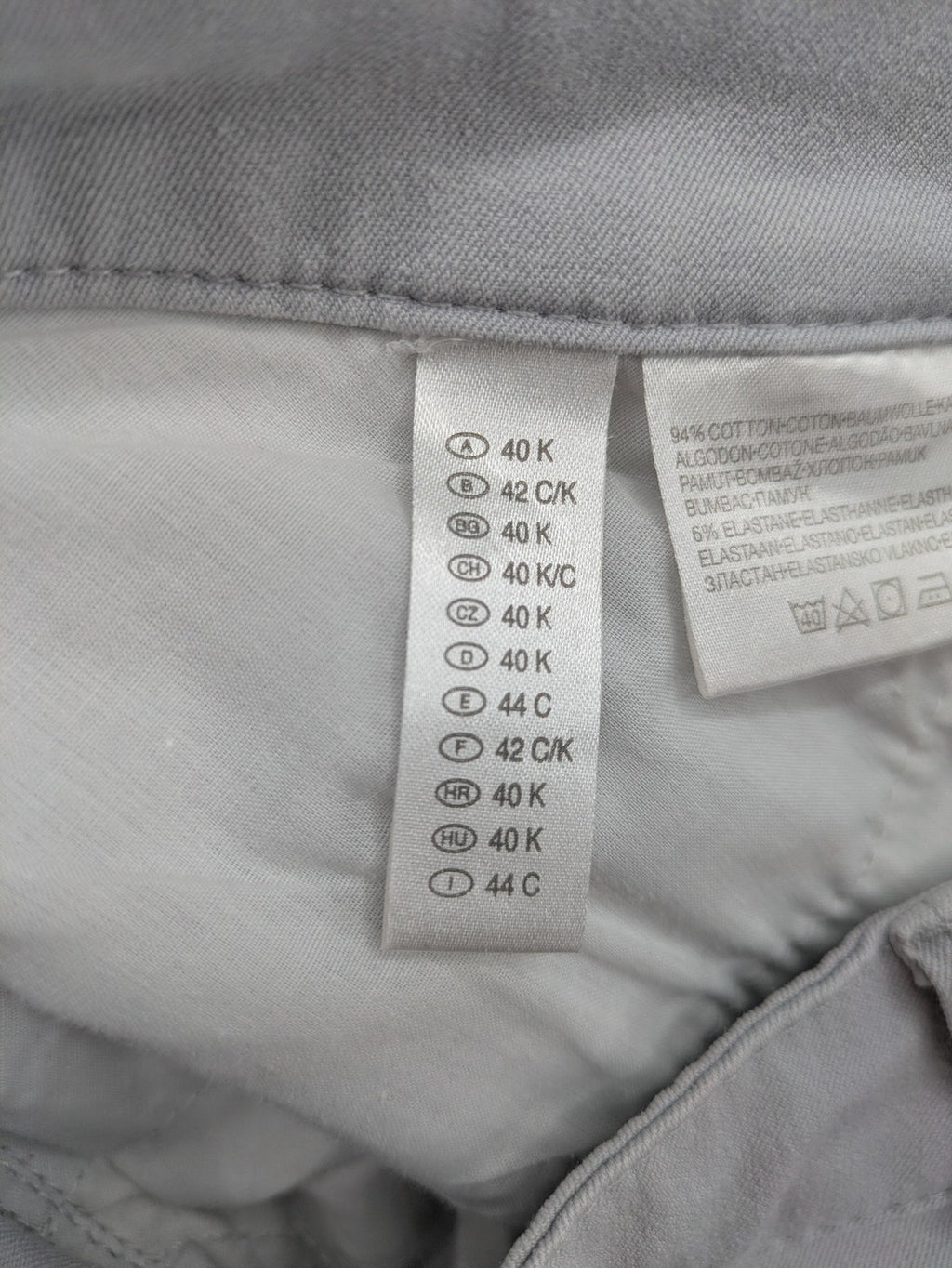 Chino grey capri pants five-pocket design with subtle embroidery and stretch cotton blend.