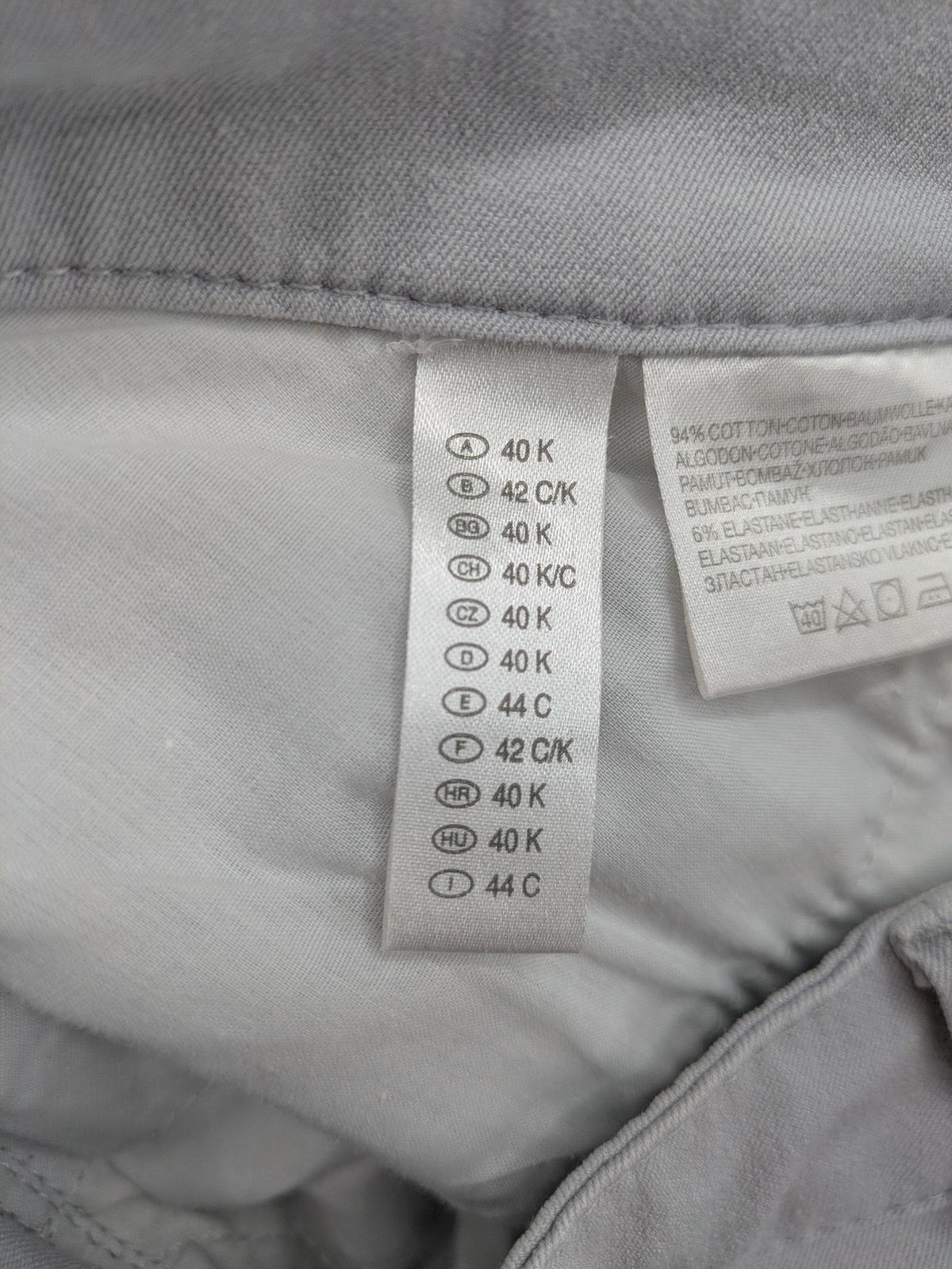 Chino grey capri pants five-pocket design with subtle embroidery and stretch cotton blend.