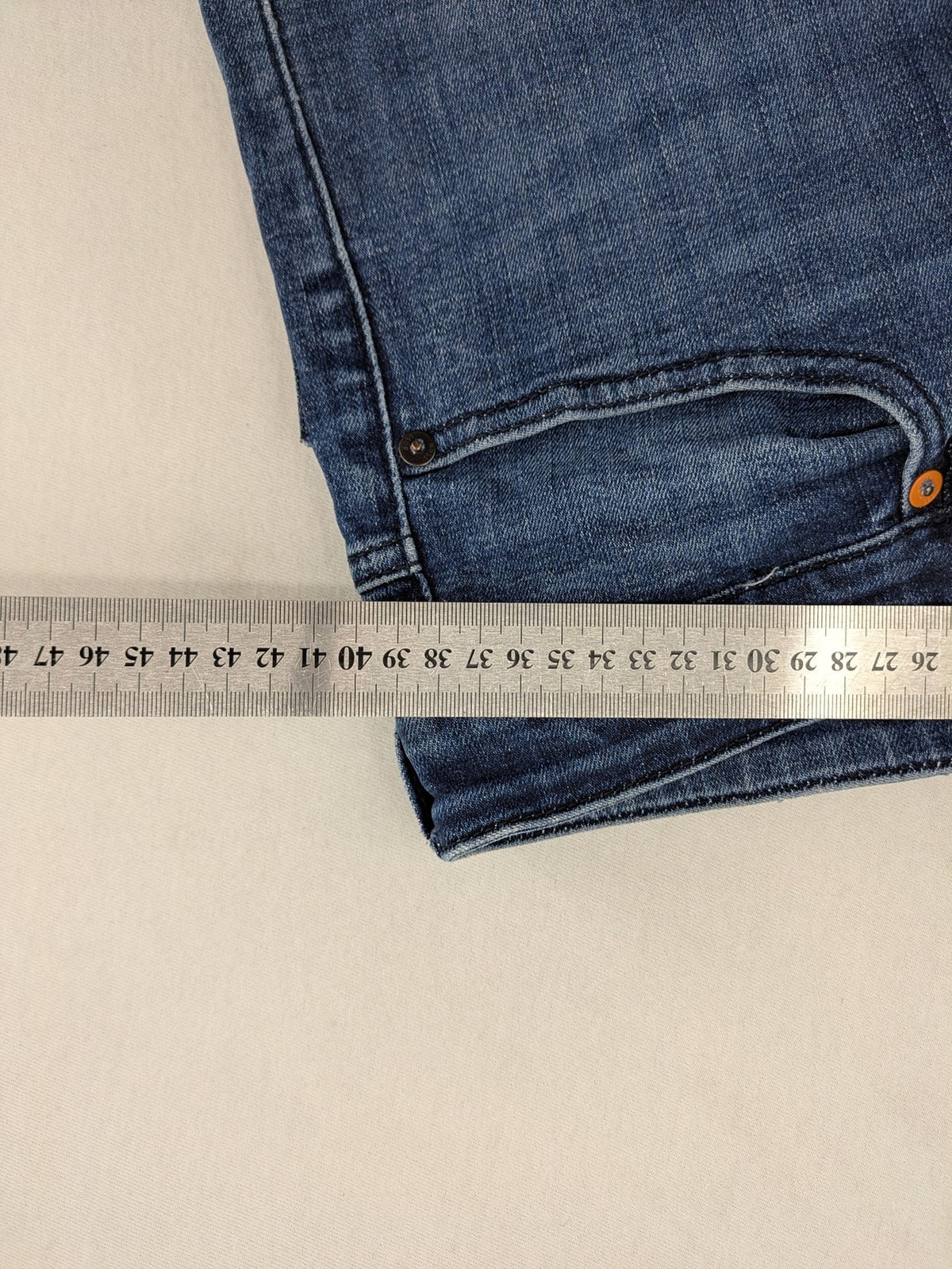 BOSS blue slim fit jeans with logo, five-pocket design, and button fly.