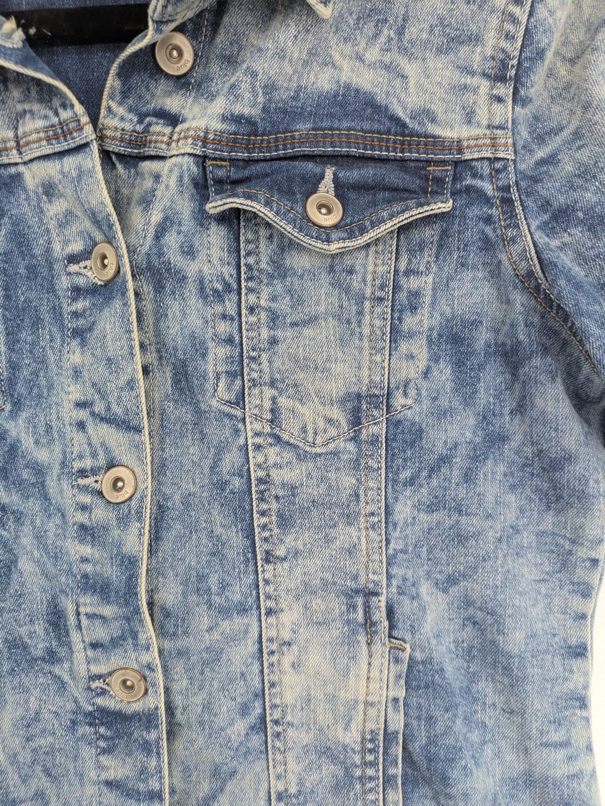 Baumwolle blue denim trucker jacket acid wash with button closure and chest pockets.