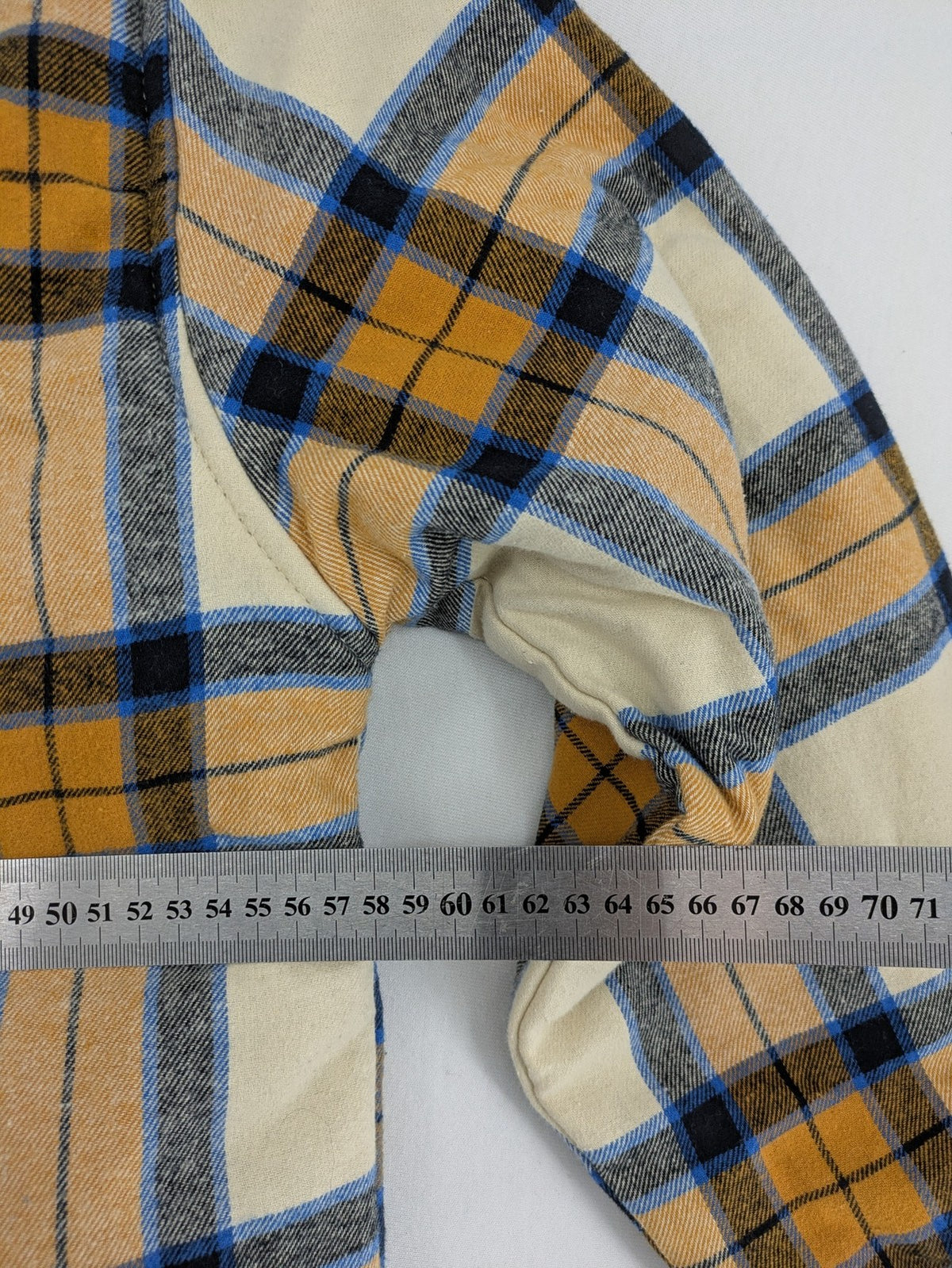 Bench cream flannel jacket with check pattern, black hood, and button placket.