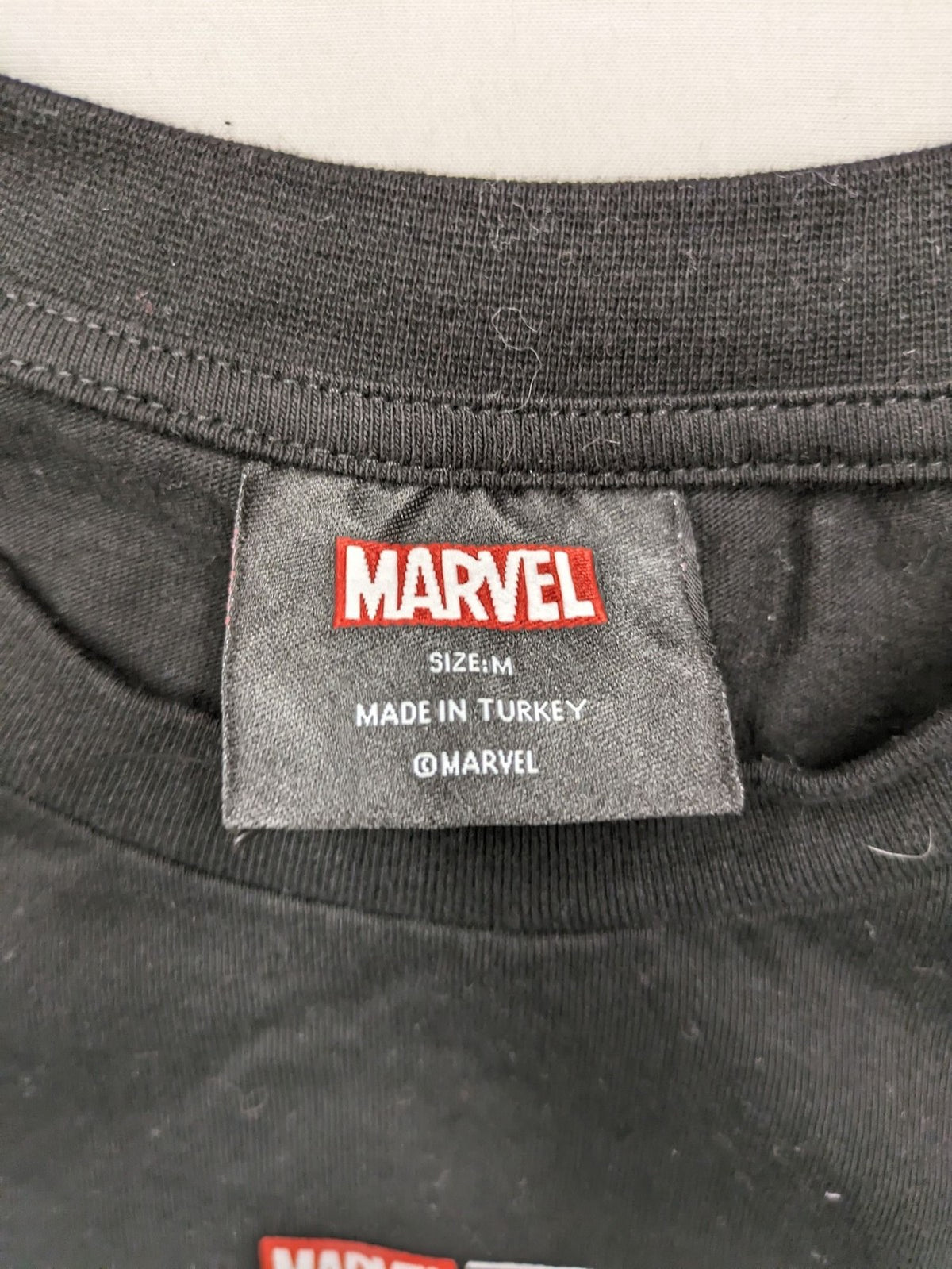 Black Panther black t-shirt foil graphic of Black Panther emblem and text.