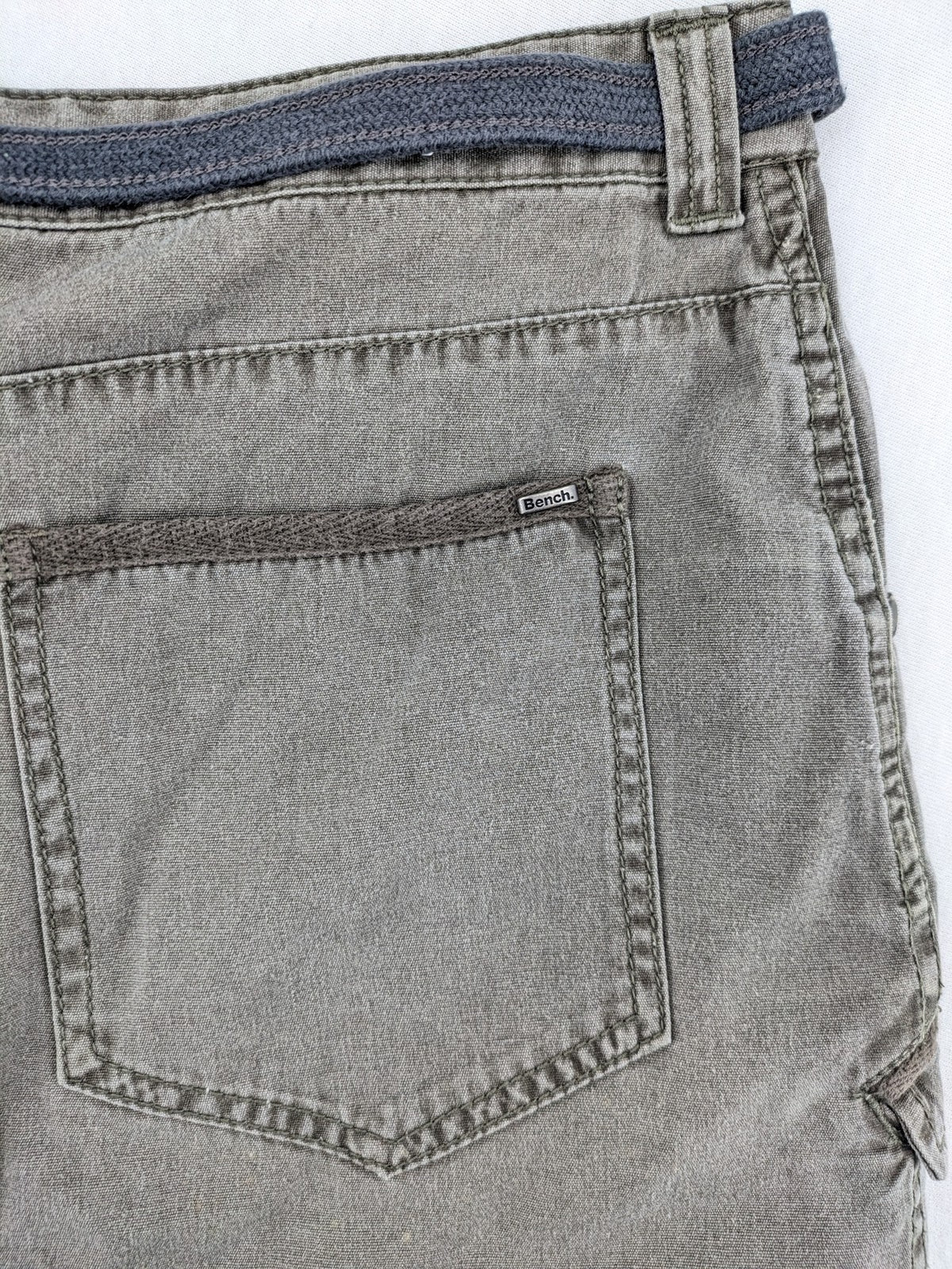 Bench khaki cargo mini skirt with belt, multiple pockets, and durable cotton material.