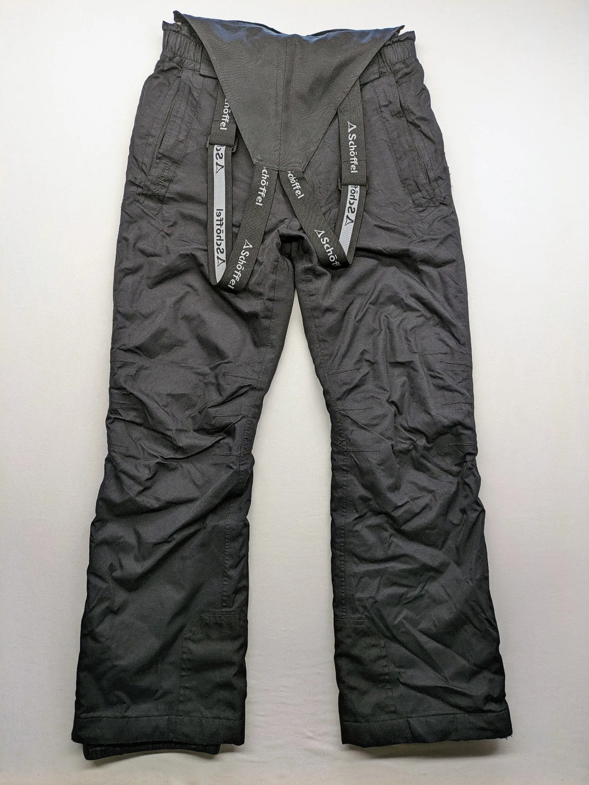 Schoffel black ski pants with adjustable straps, zip pockets, and snow gaiters.