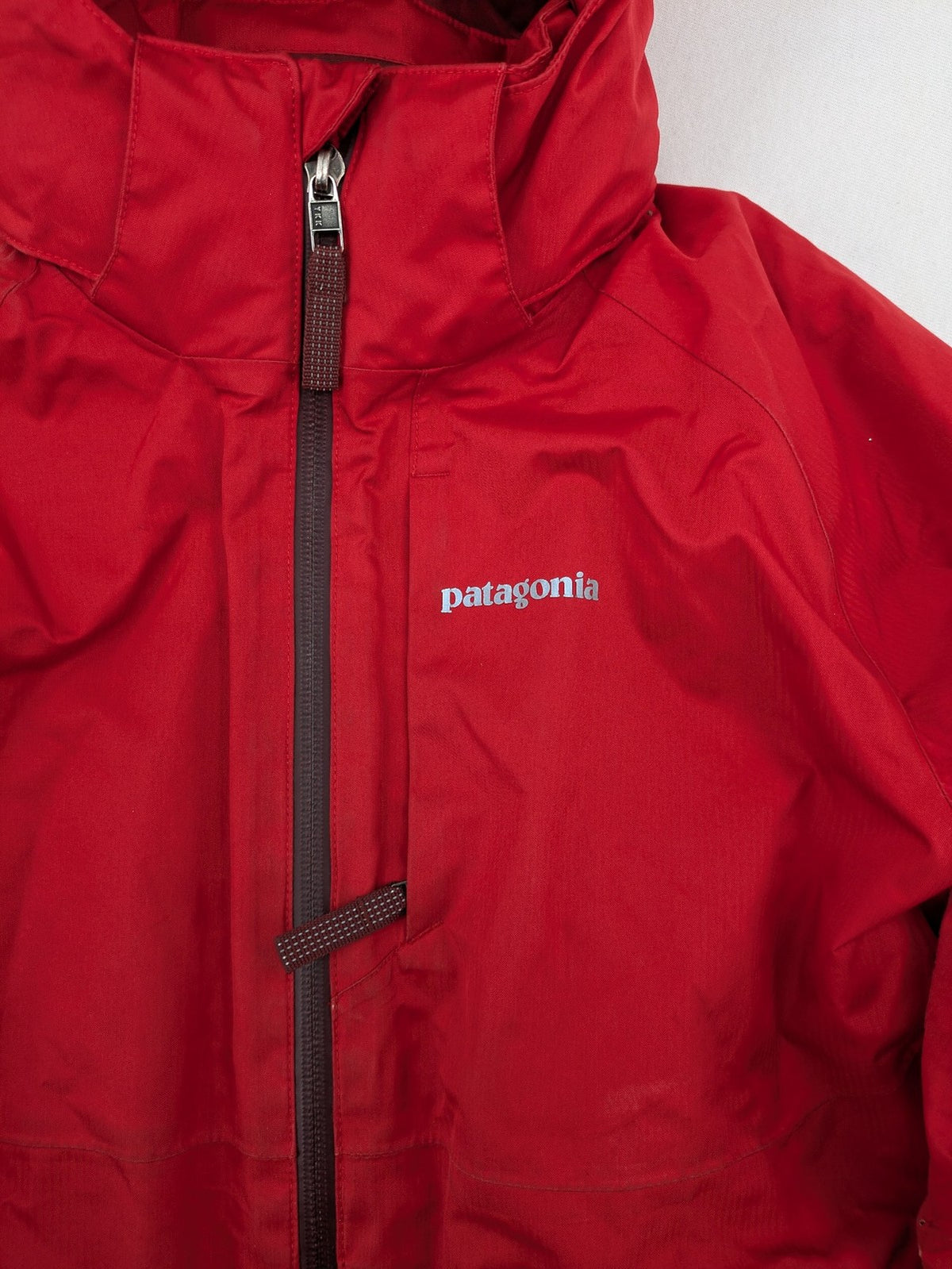 Patagonia red winter coat with hood, zip closure, snow skirt, and ski pass pocket.