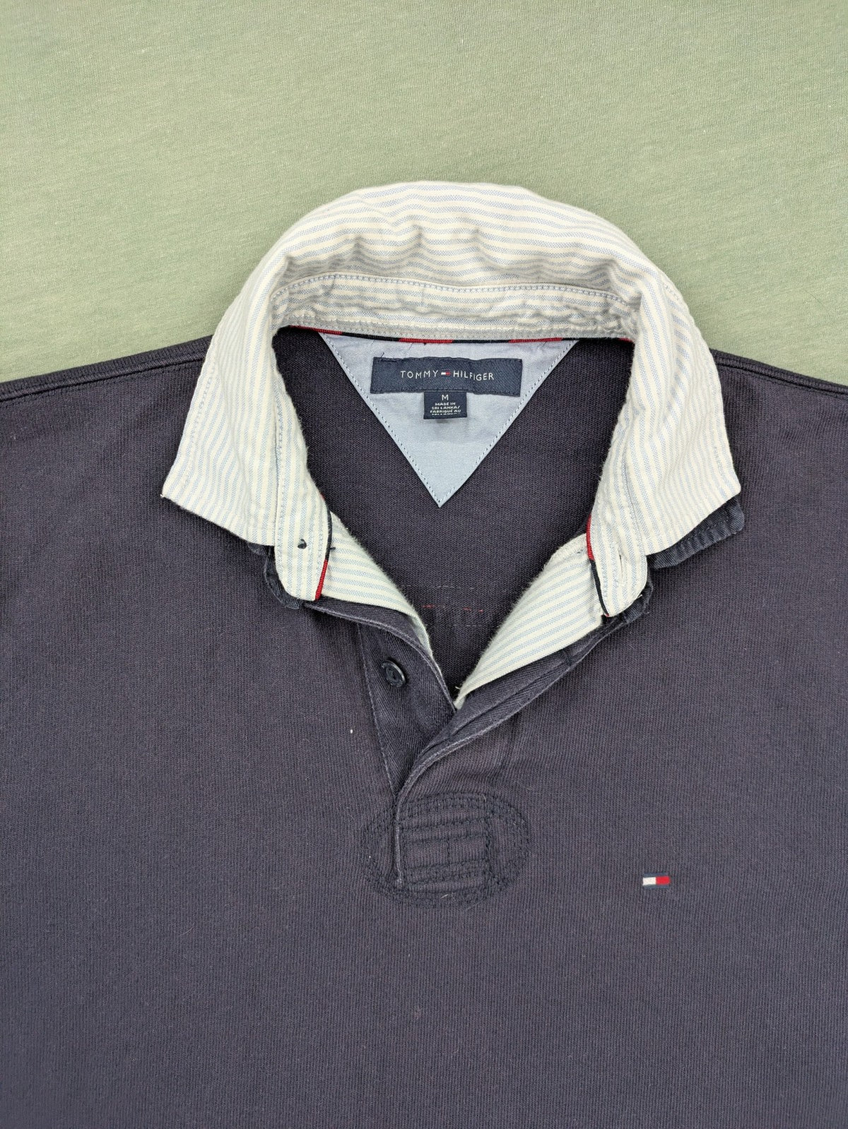 Tommy Hilfiger grey rugby polo shirt with navy striped collar and large H logo.