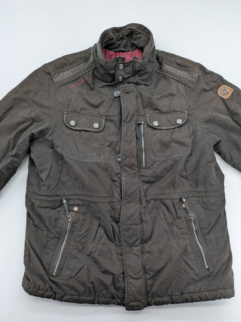 Gate One brown field jacket with plaid lining, multiple pockets, and zip-button closure.