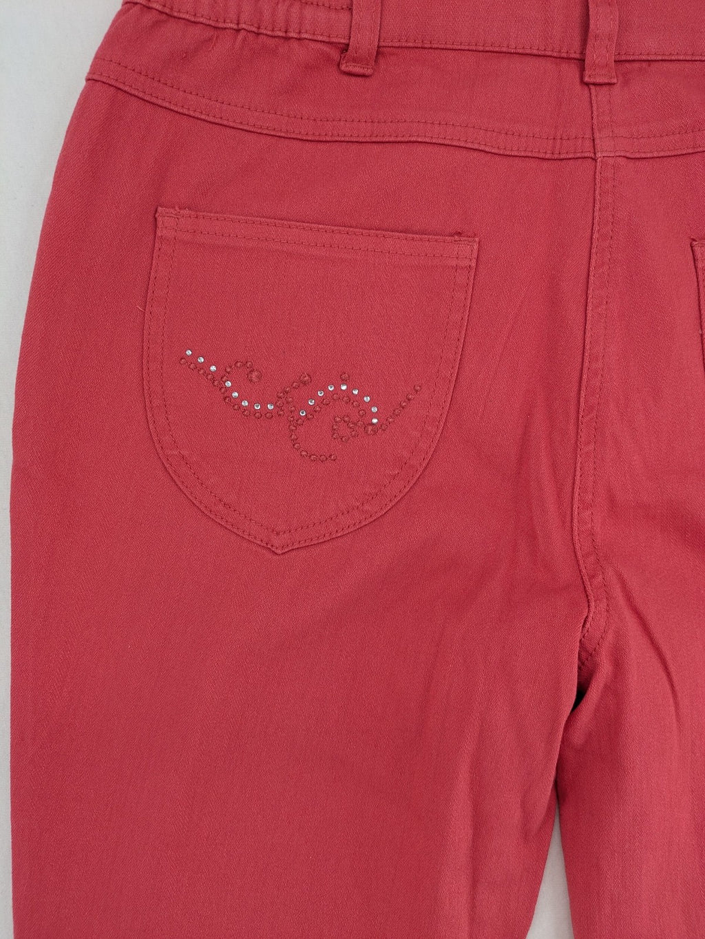 Helena Vera red straight jeans with elastic waistband and rhinestone details on pockets.